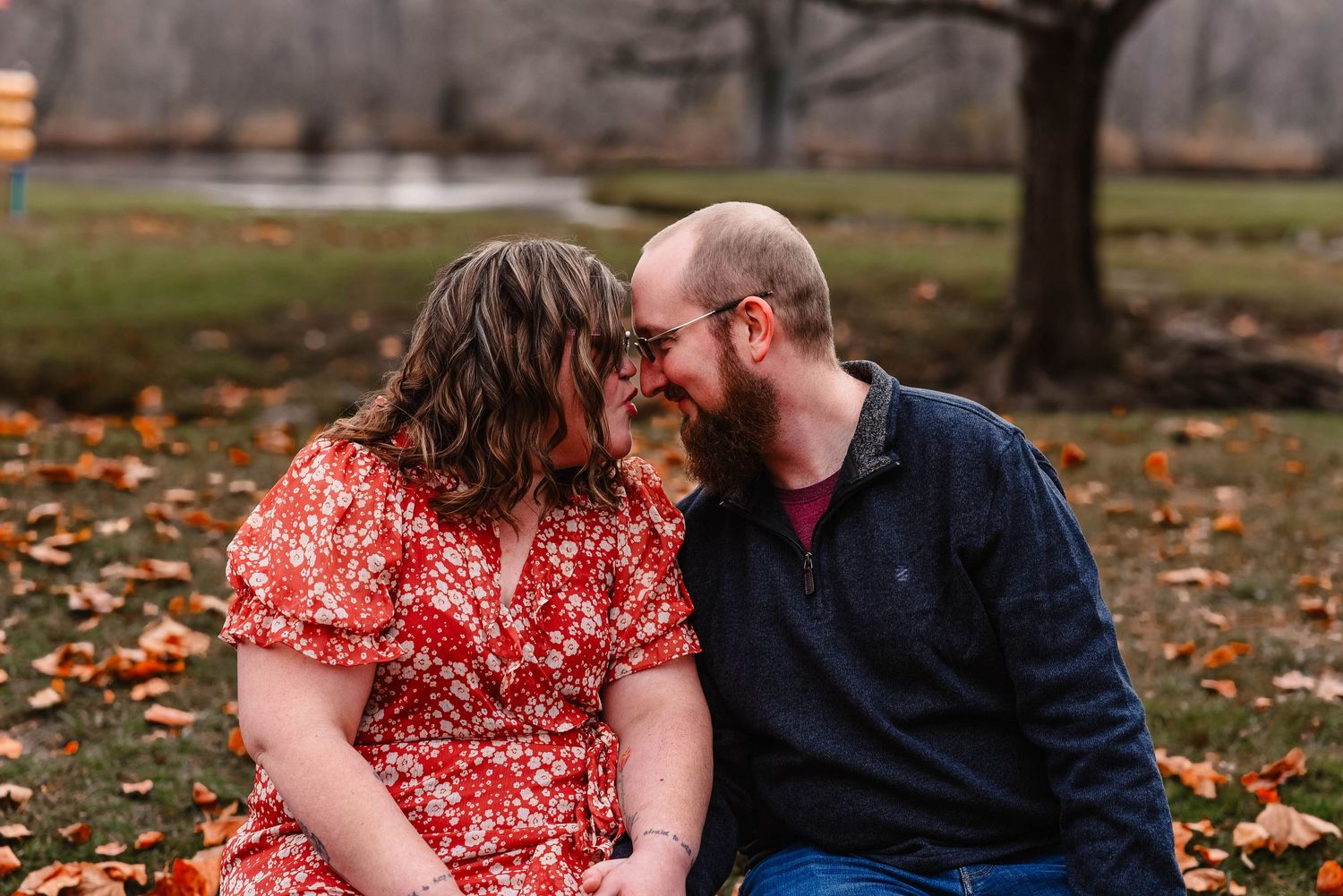 Intimate moment between couple during autumn engagement photography session.