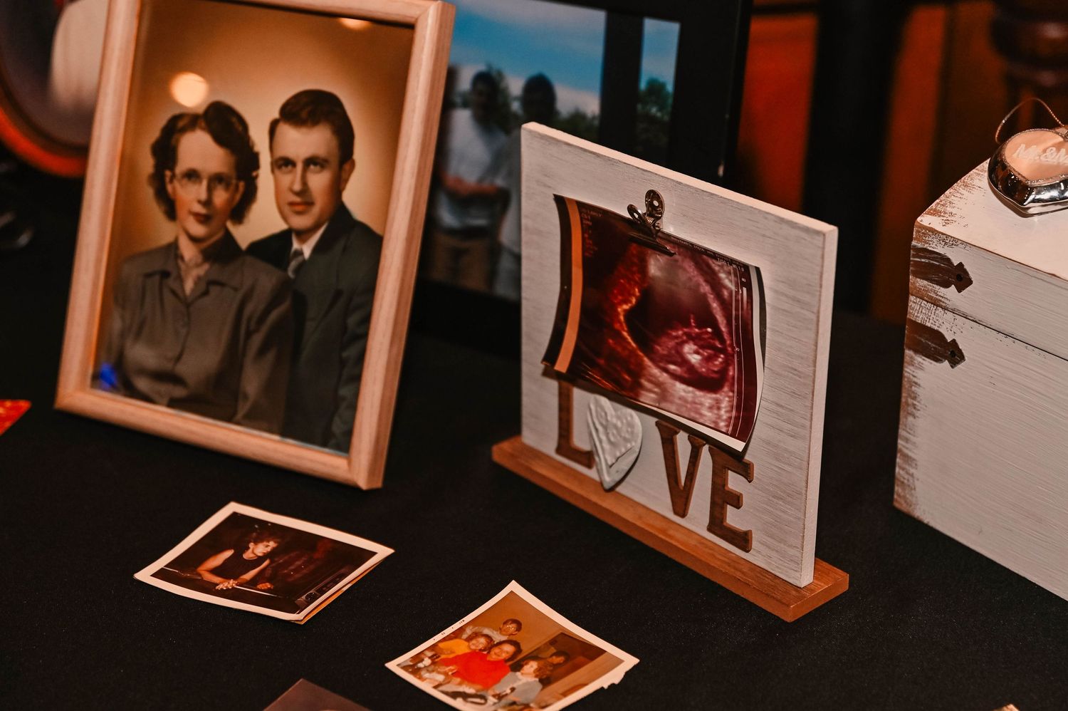 Collection of framed photographs displayed in warm lighting at wedding reception.