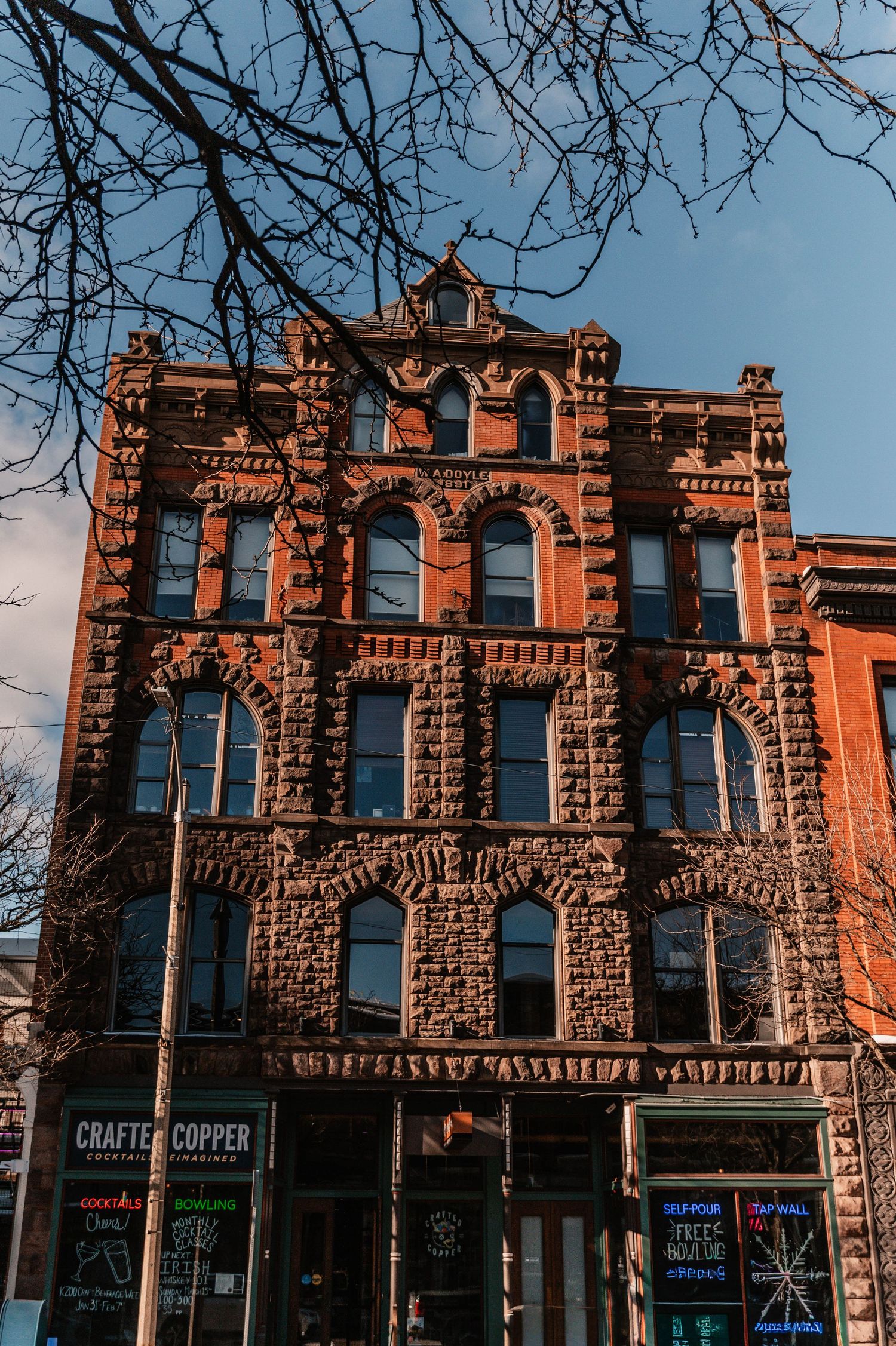 Historic red brick buildings with ornate stone facades line a commercial street.