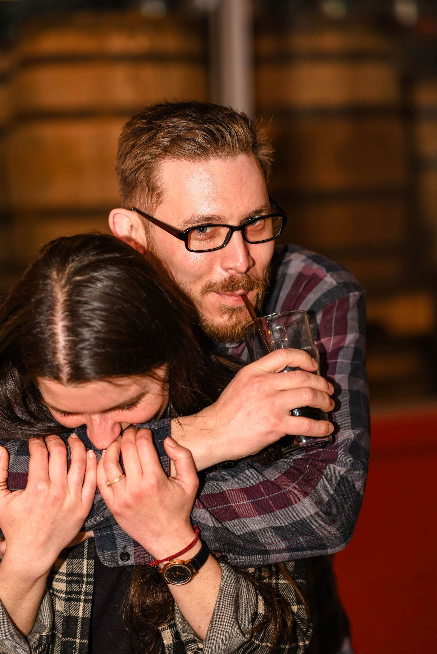 A candid moment of laughter and playfulness captured in warm indoor lighting.