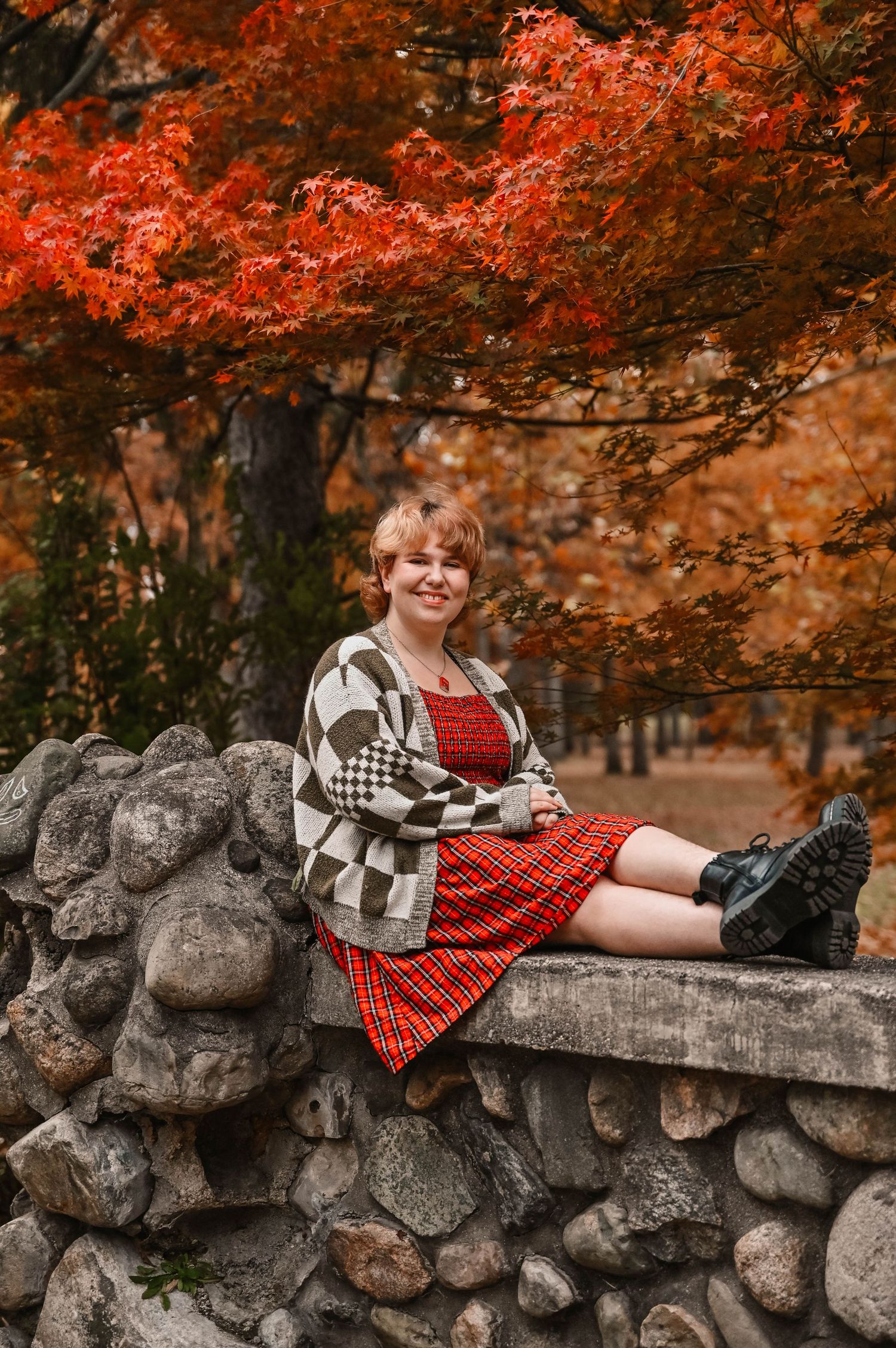 Stone wall setting with vibrant red maple trees creating a scenic autumn backdrop.