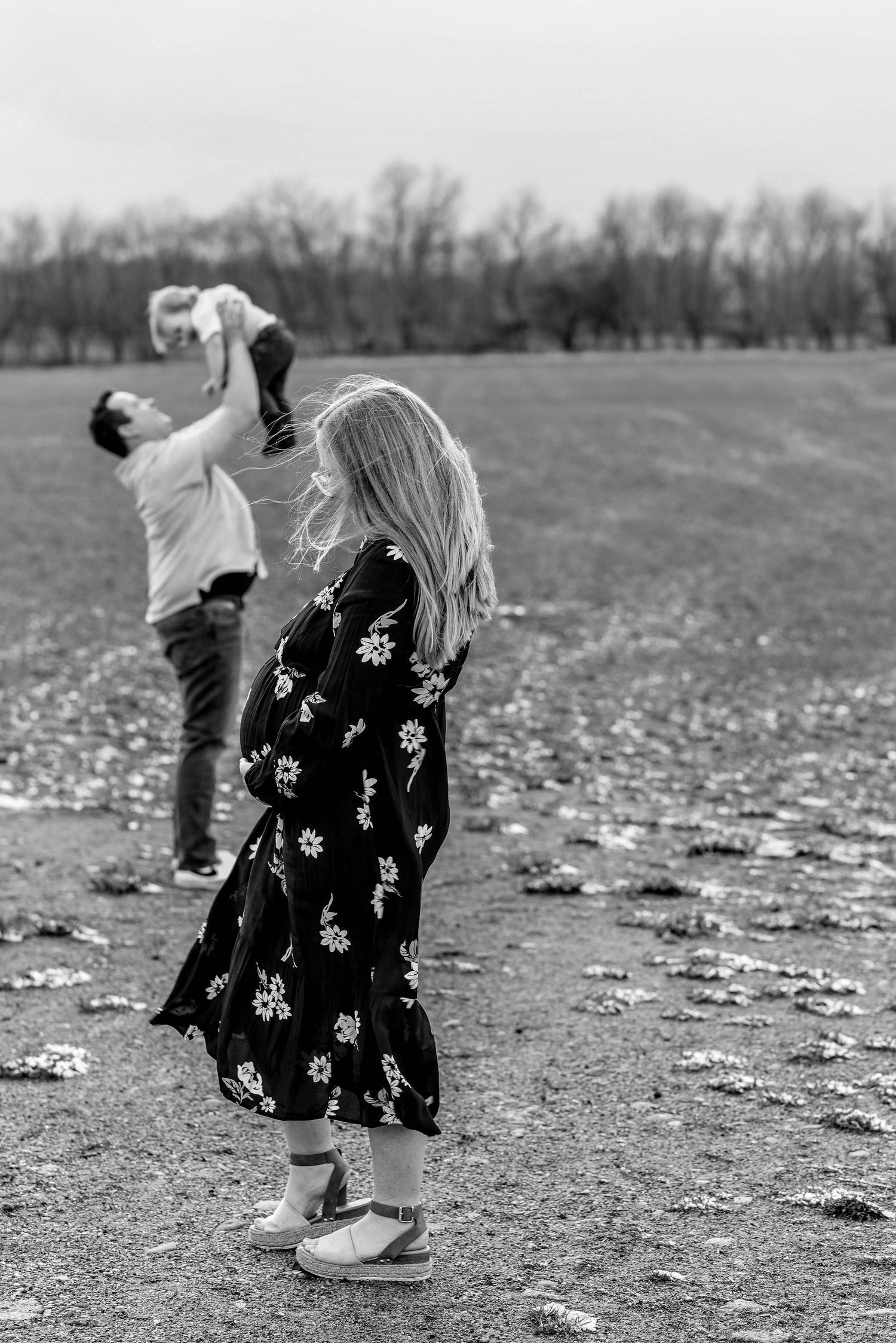 Black and white photo of people dancing and playing in an open field.