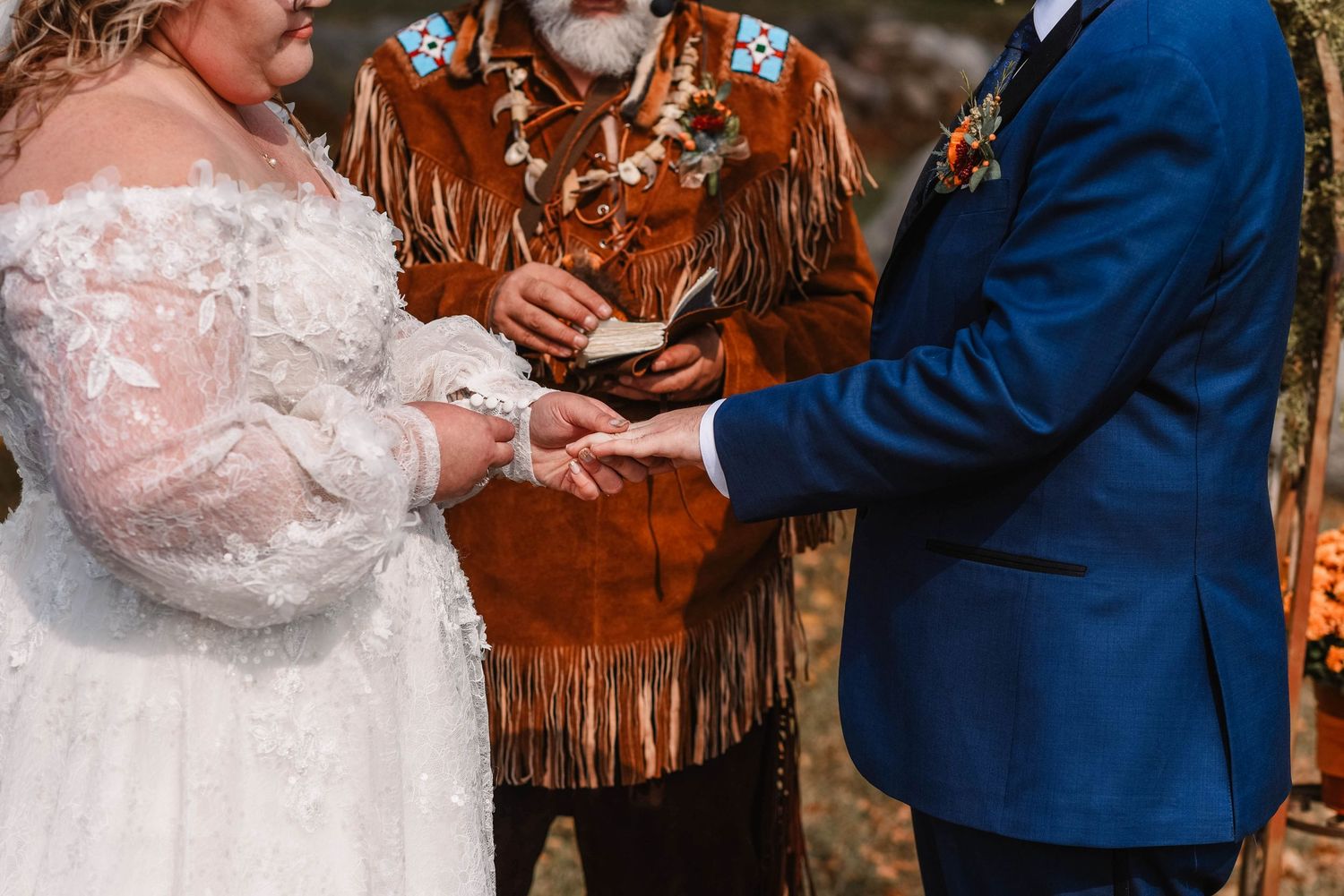 Wedding ceremony moment with rustic autumn-themed decor and orange details.