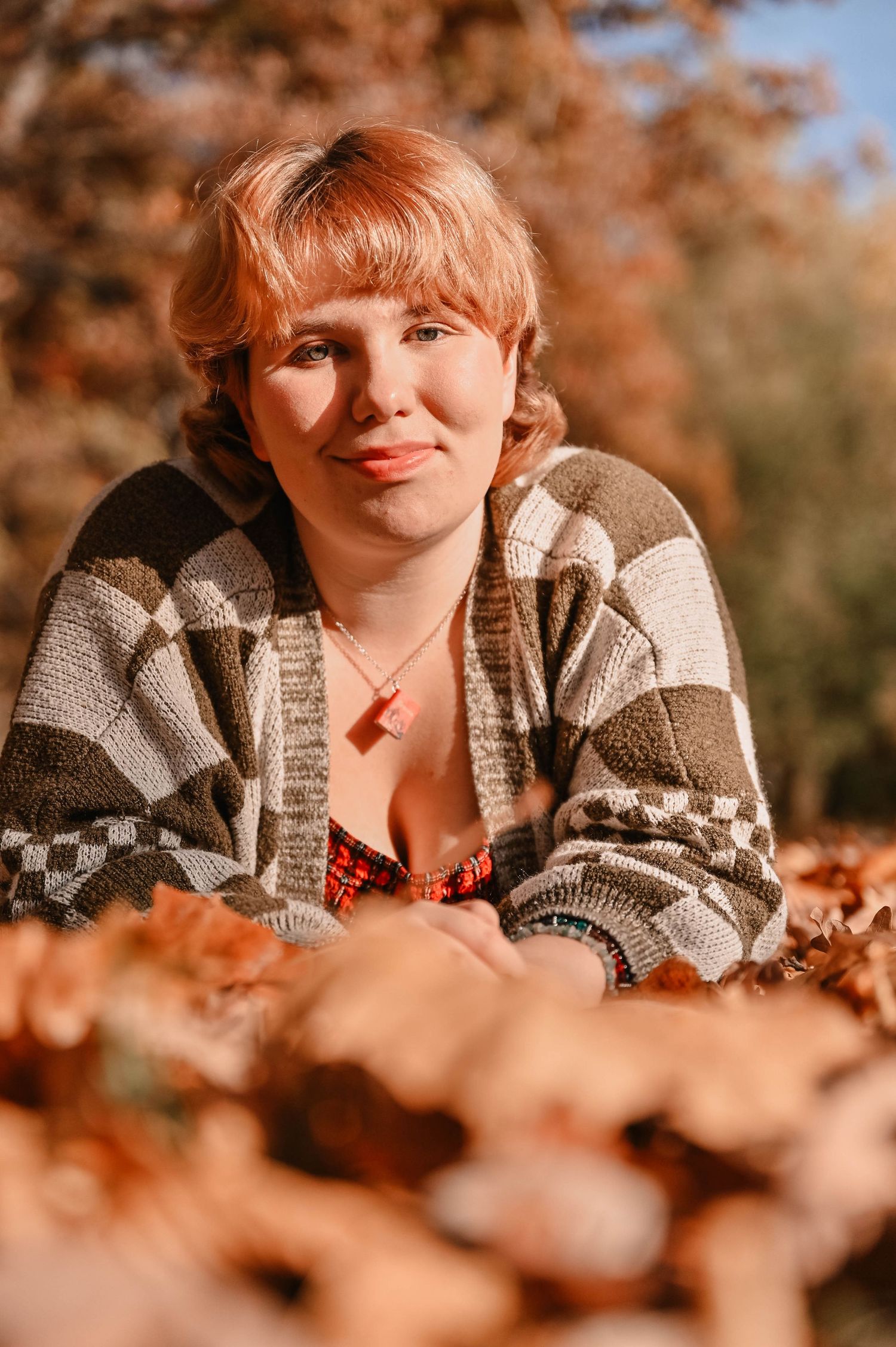 Portrait in autumn setting with warm lighting and fall foliage.