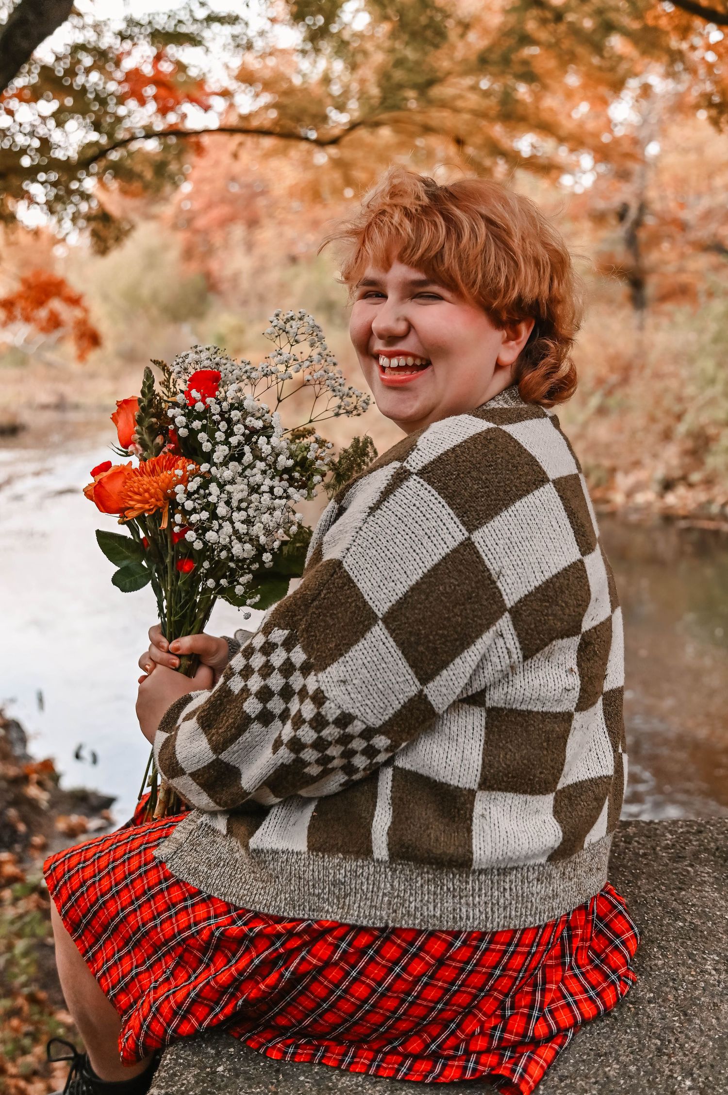 Autumn portrait with bouquet of roses and baby's breath against fall foliage.
