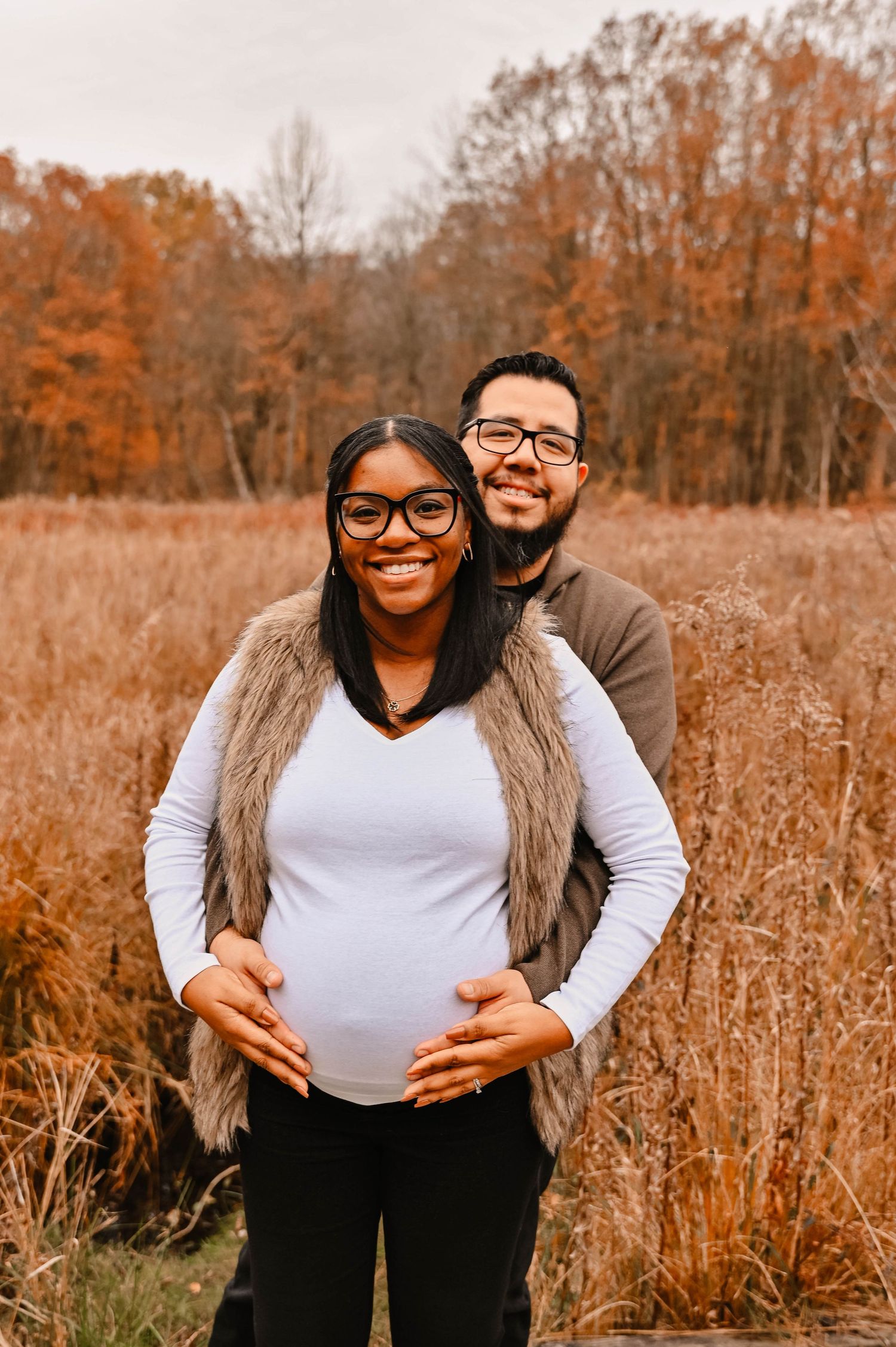 A loving embrace captured in a golden autumn field with tall grass.