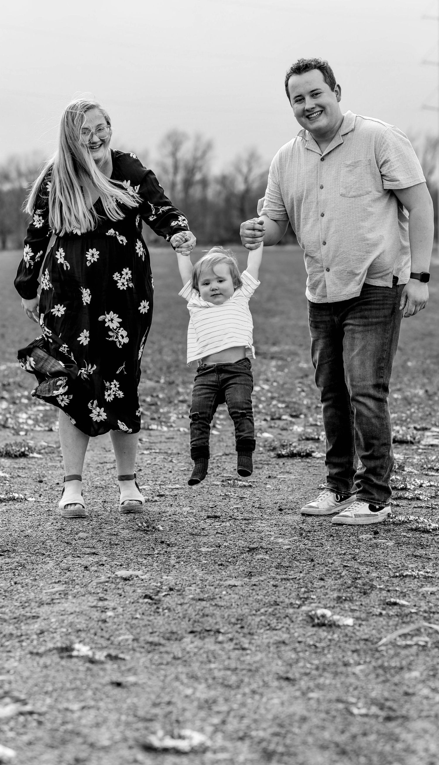 Black and white photo of family members walking together on rural ground.