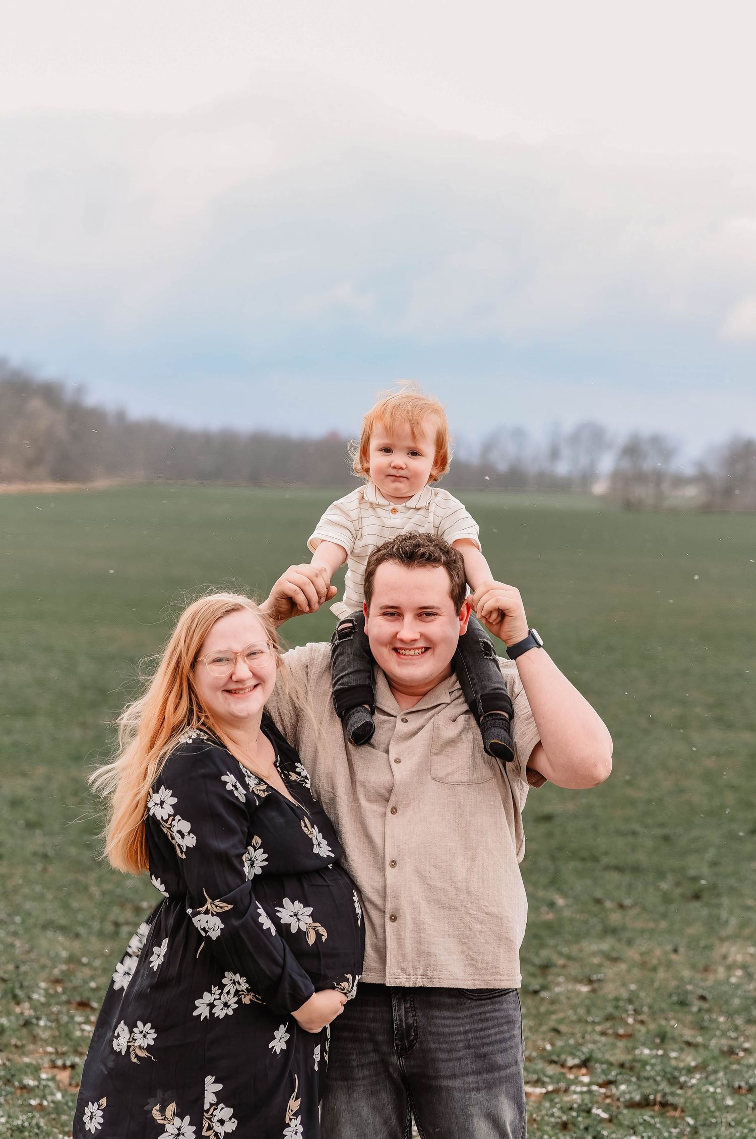 Family having fun and laughing together in a green field.