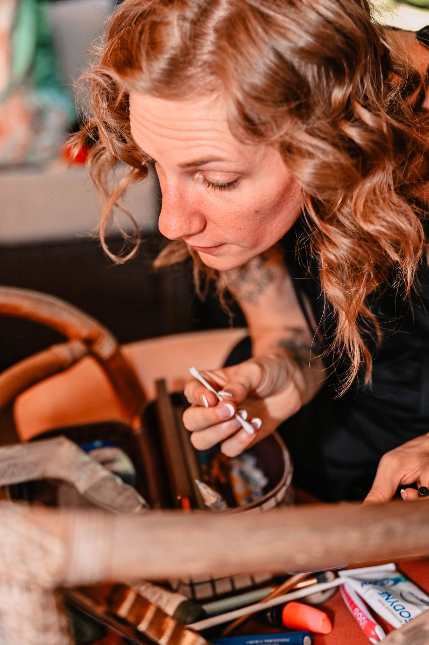 Person working on crafts or artwork at a desk with focused concentration.