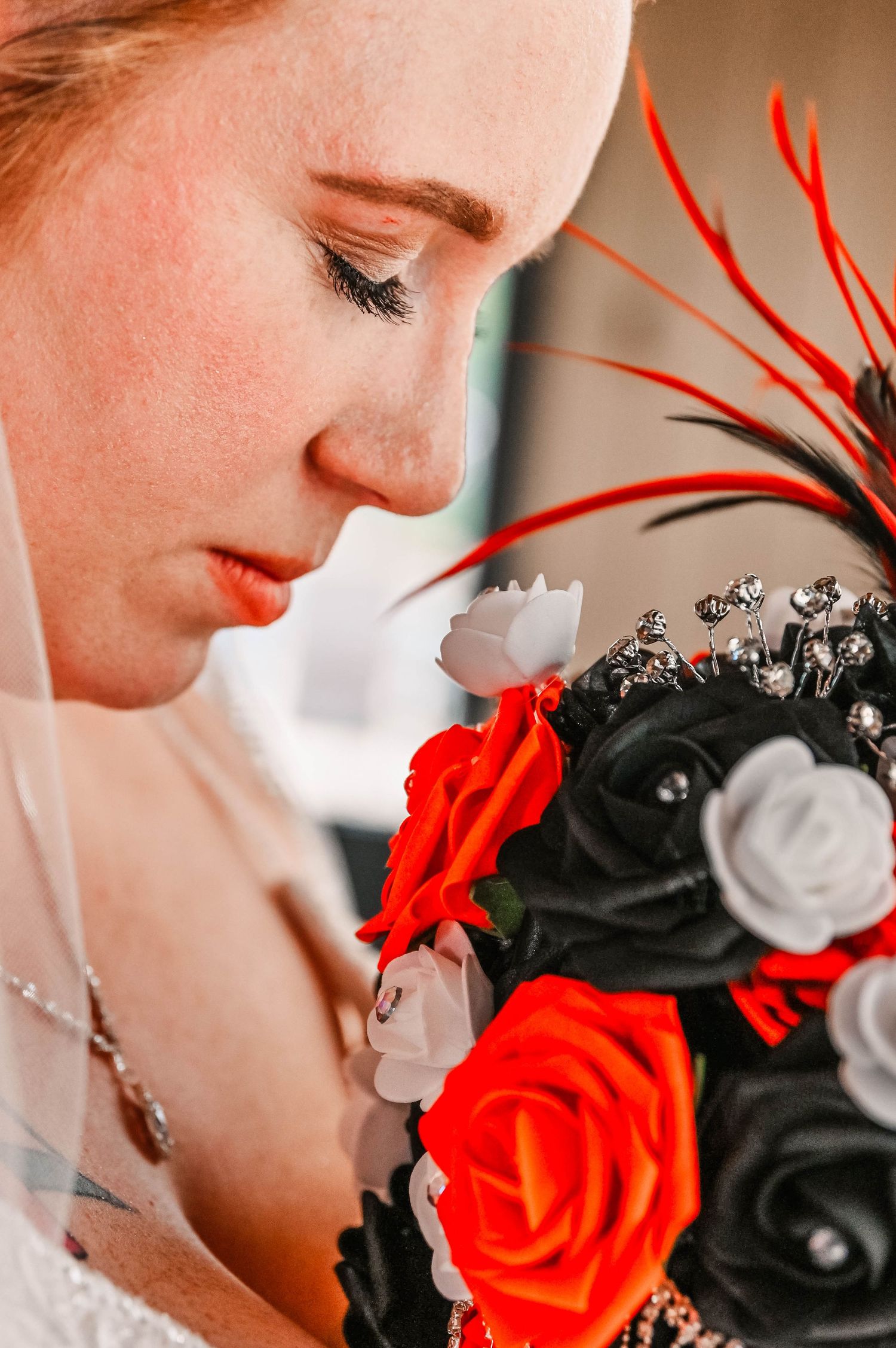 A close-up profile view with red and black roses in the foreground.