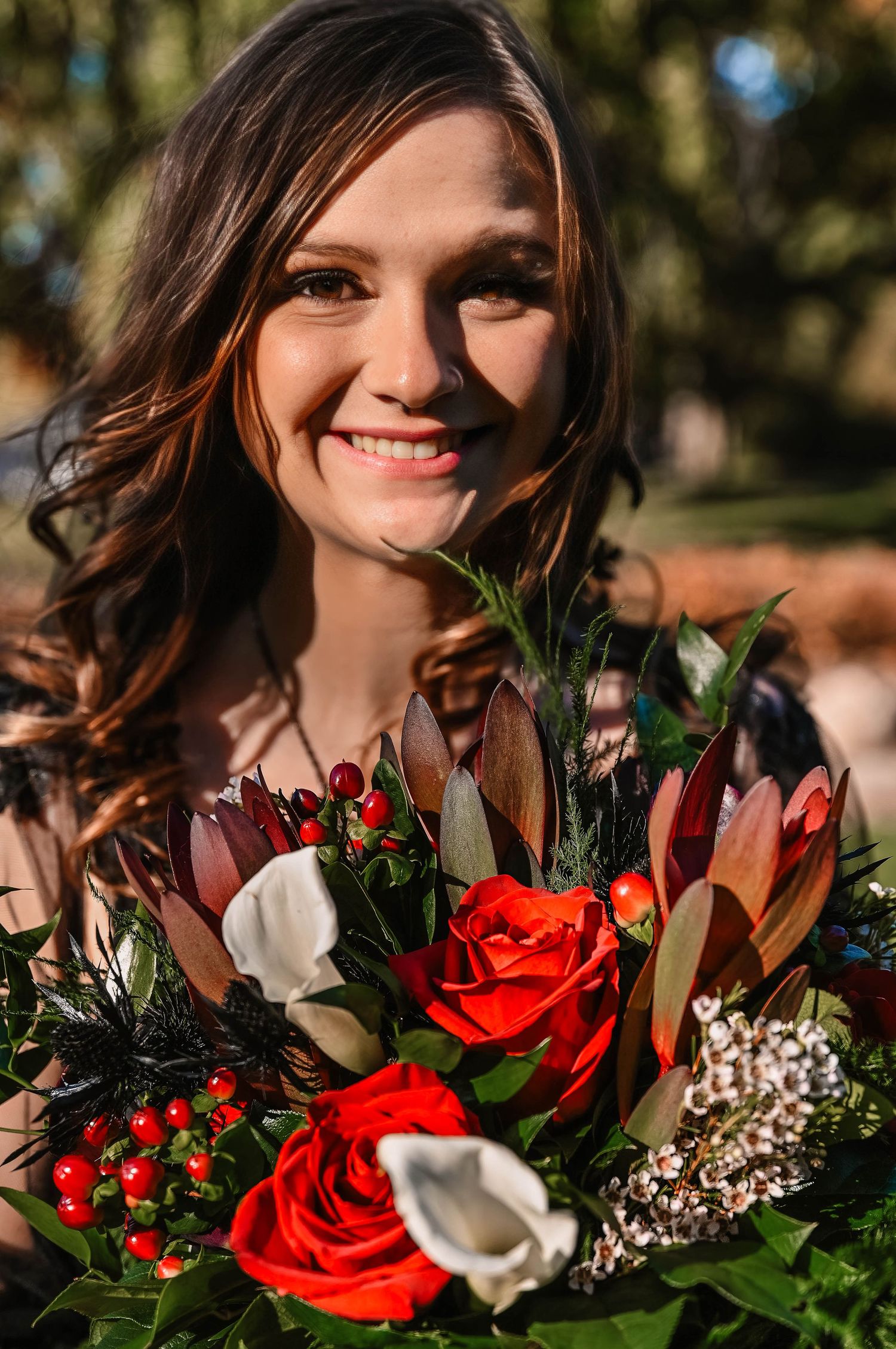 Beautiful red and white wedding bouquet with roses and greenery in natural lighting.