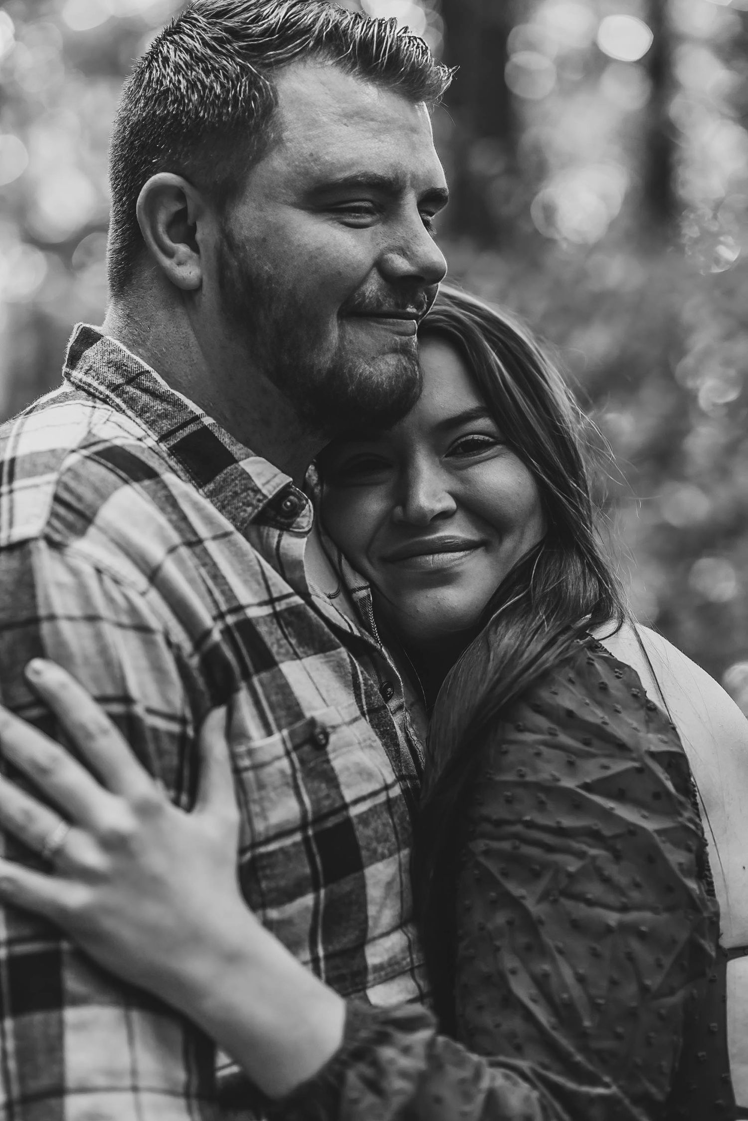 Black and white romantic couple photos showing tender embraces in a natural outdoor setting.