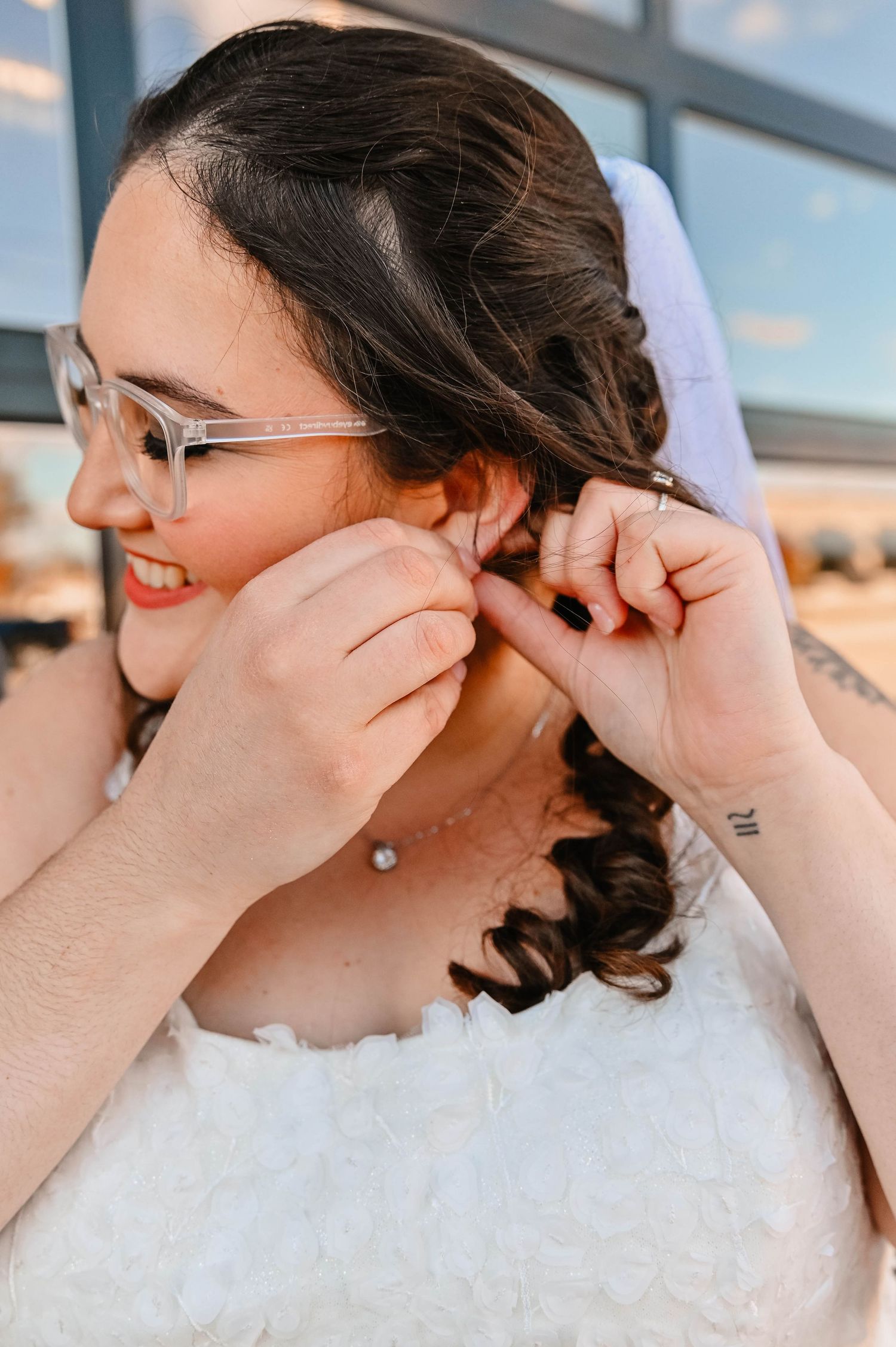 Close-up shot of jewelry being put on during wedding preparations.