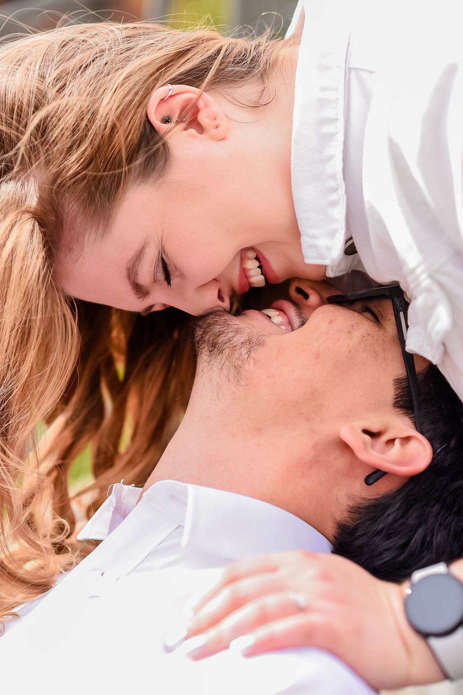 Intimate romantic couple sharing passionate kisses in white attire.