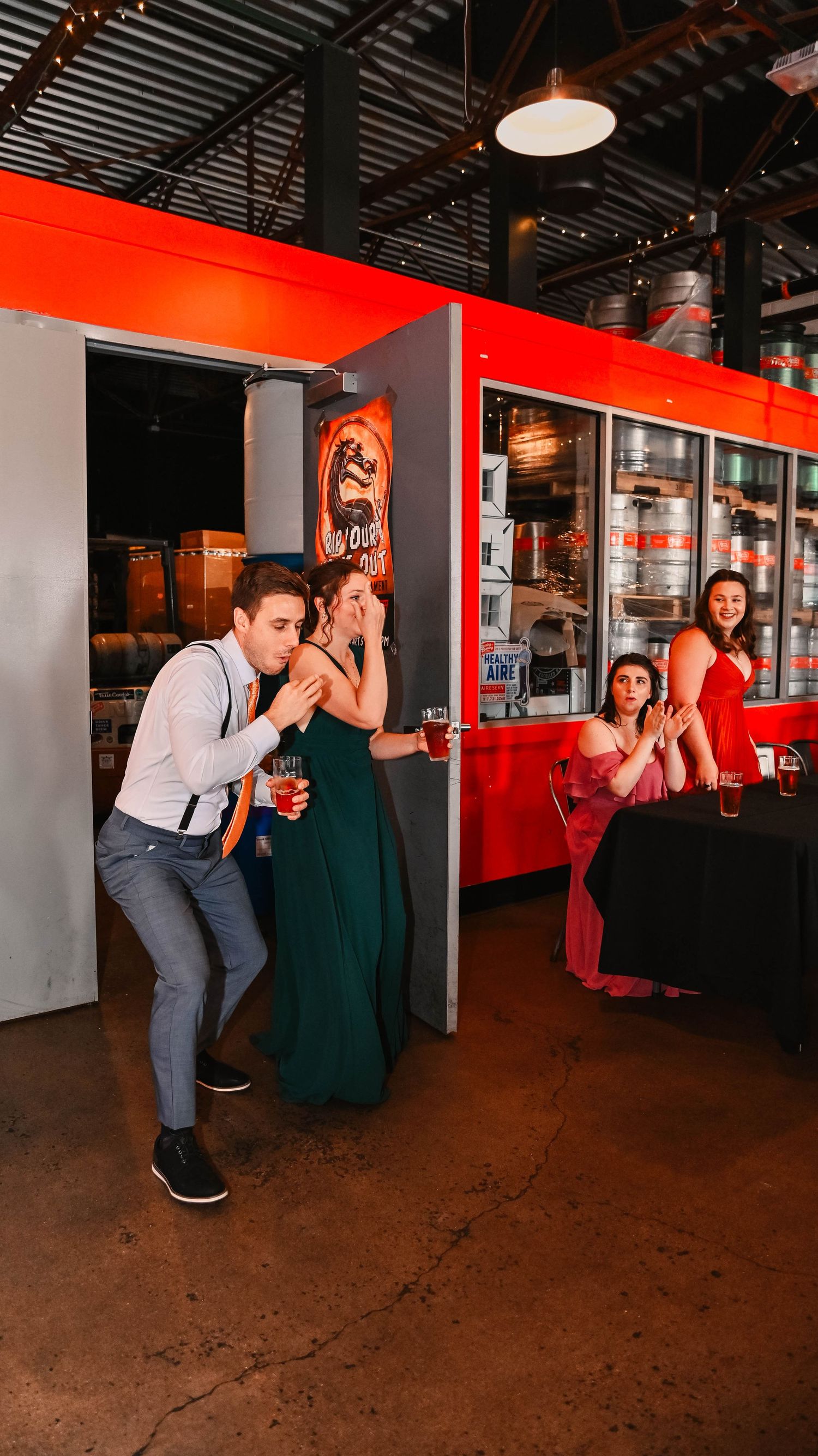 Group performs synchronized dance routine in industrial venue with red accent walls.