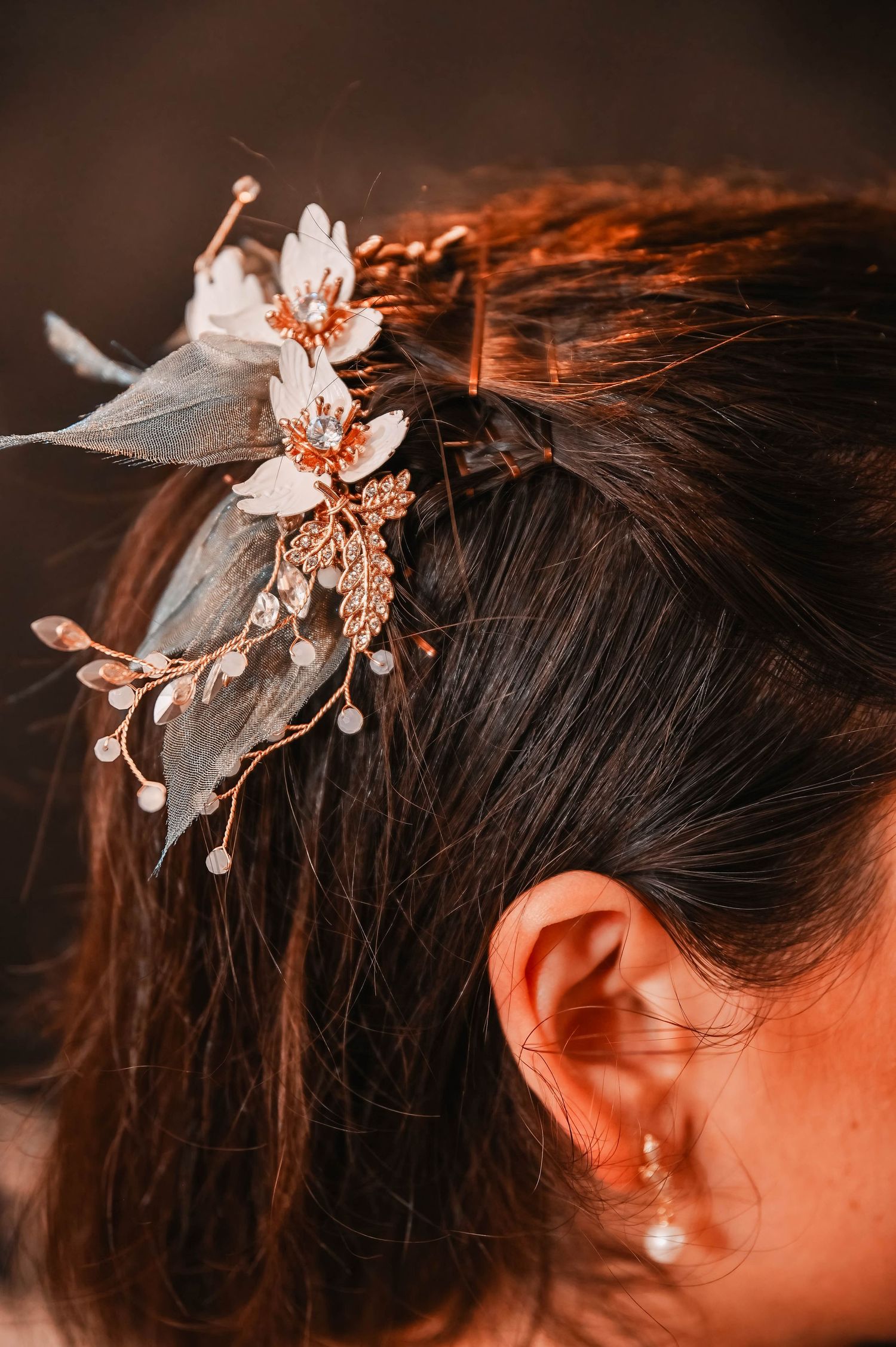 Delicate floral hair accessories with pearl details in warm lighting.