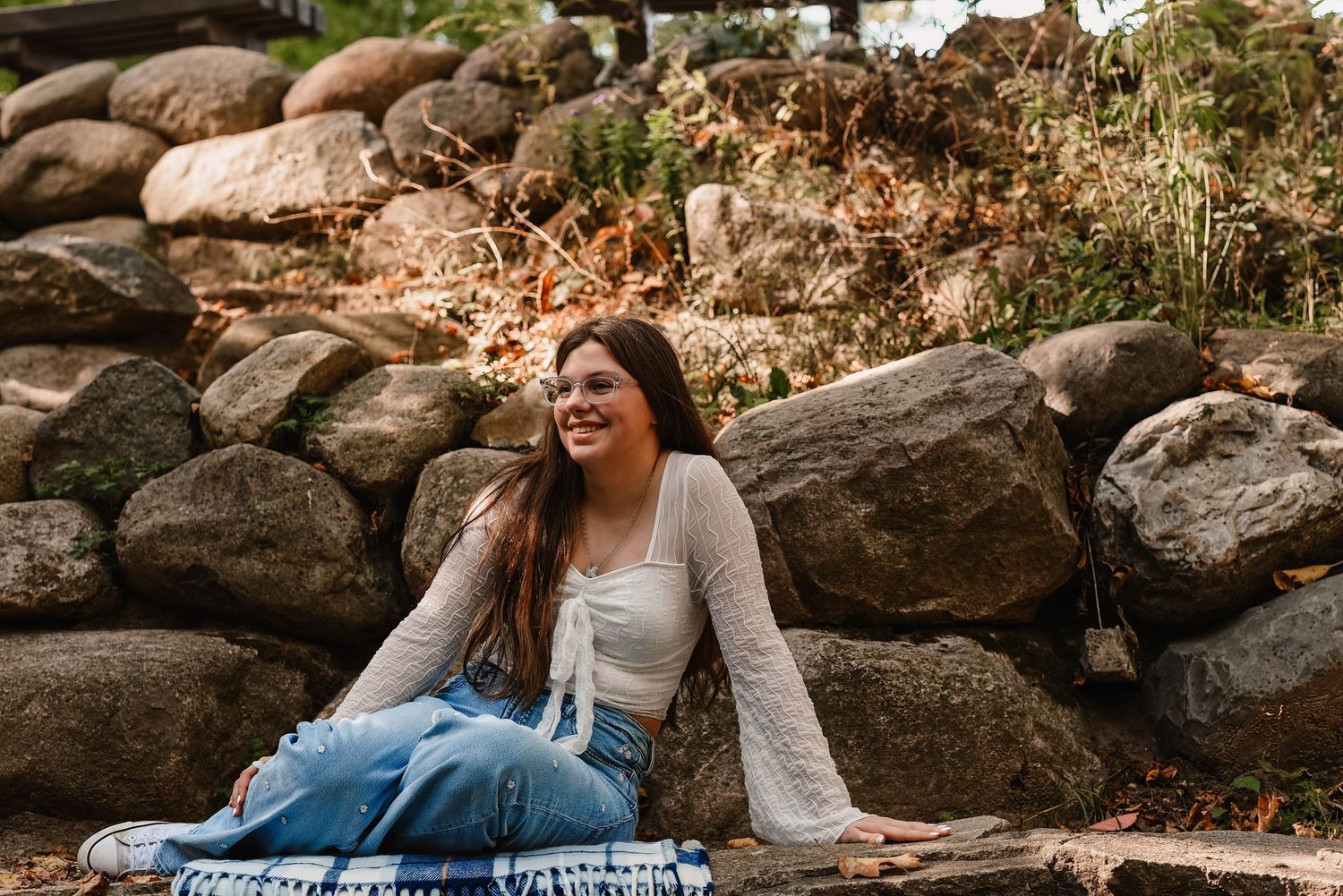 Casual outdoor portraits on rocks showing joyful expressions and relaxed poses.