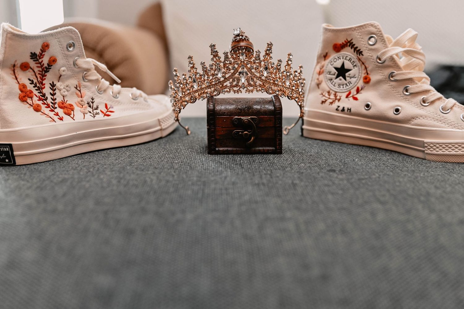 Artistic flat lay of cream colored sneakers with floral details.