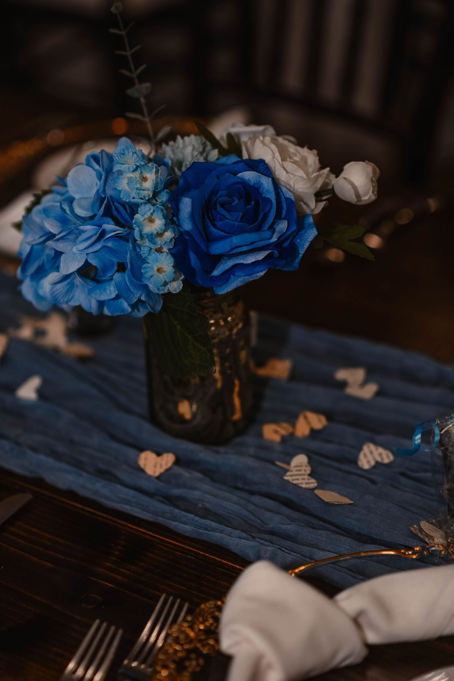 Table decor featuring bright blue flowers and butterfly accents.