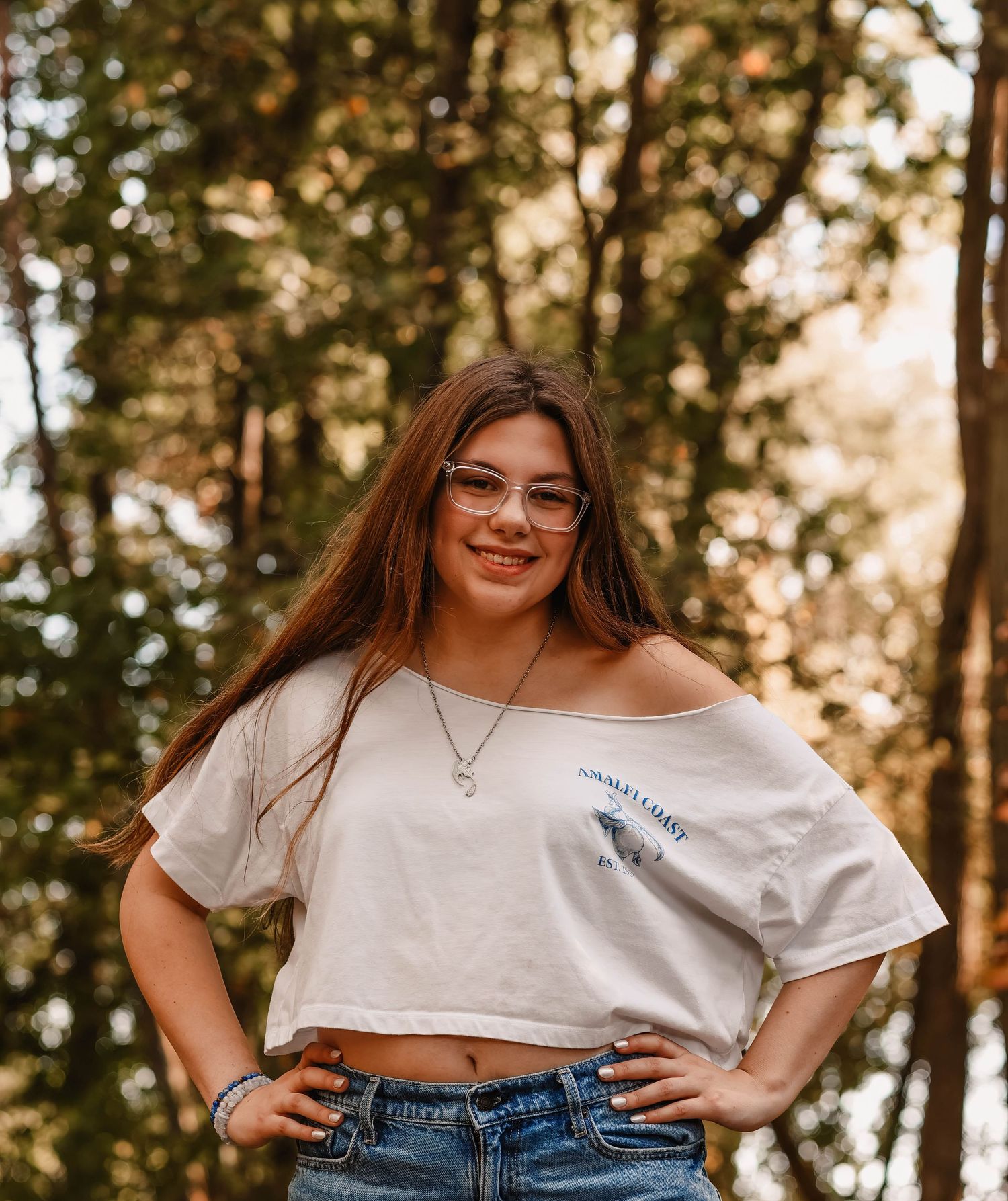 Casual outdoor portraits in white crop top and jeans among trees.