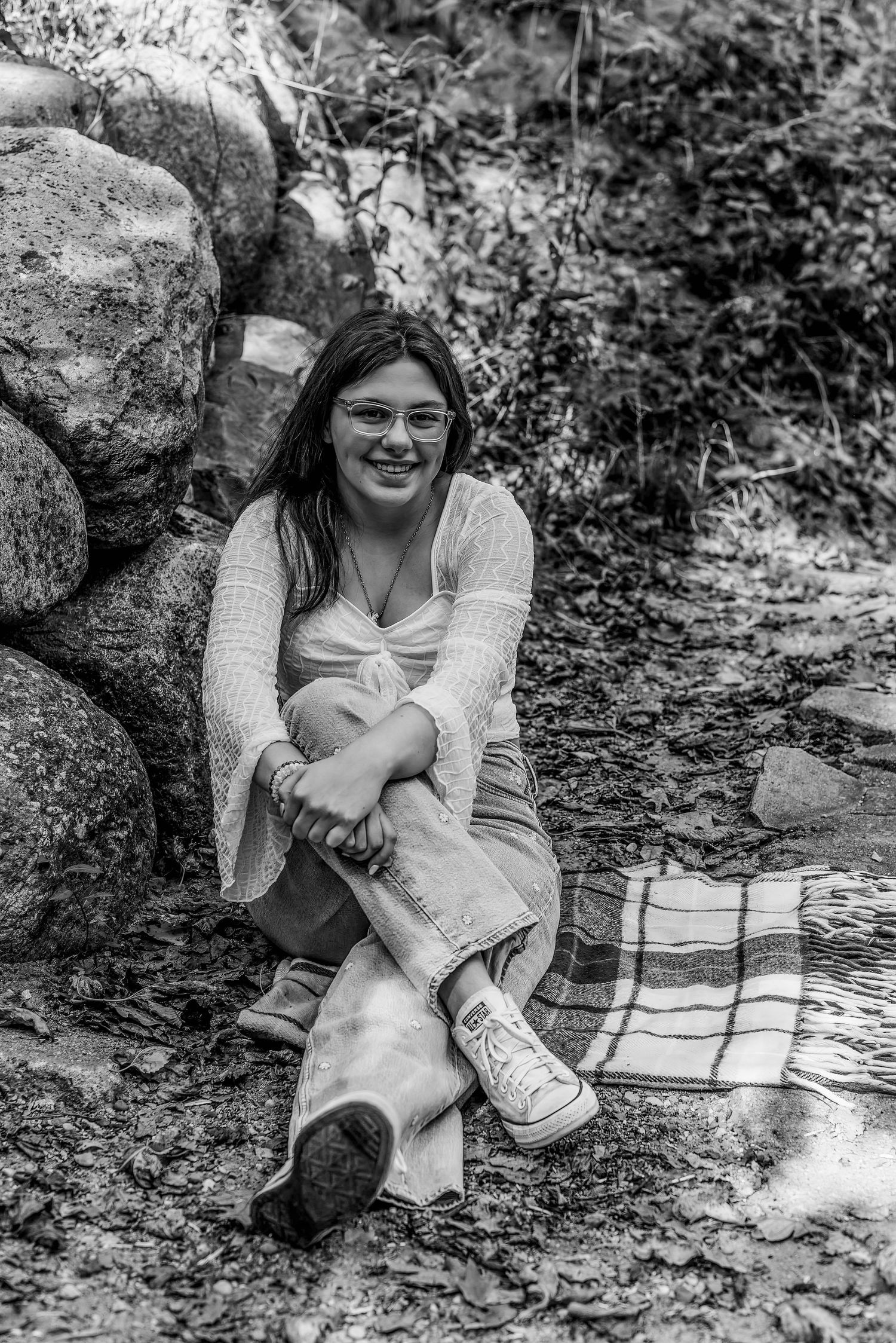 Black and white portraits on a blanket by rocks showing natural expressions.
