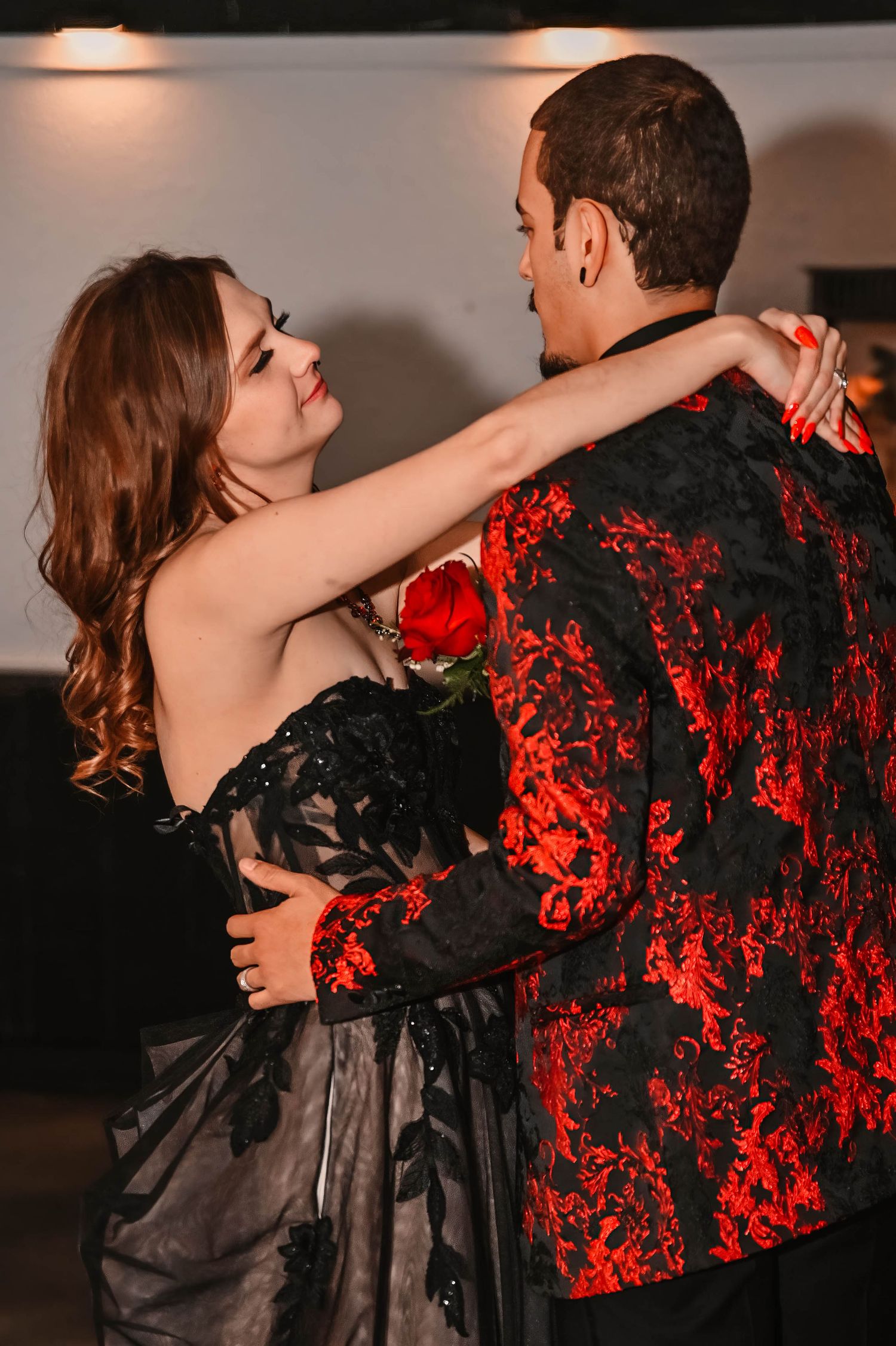 Dancers in formal attire performing under dramatic lighting.