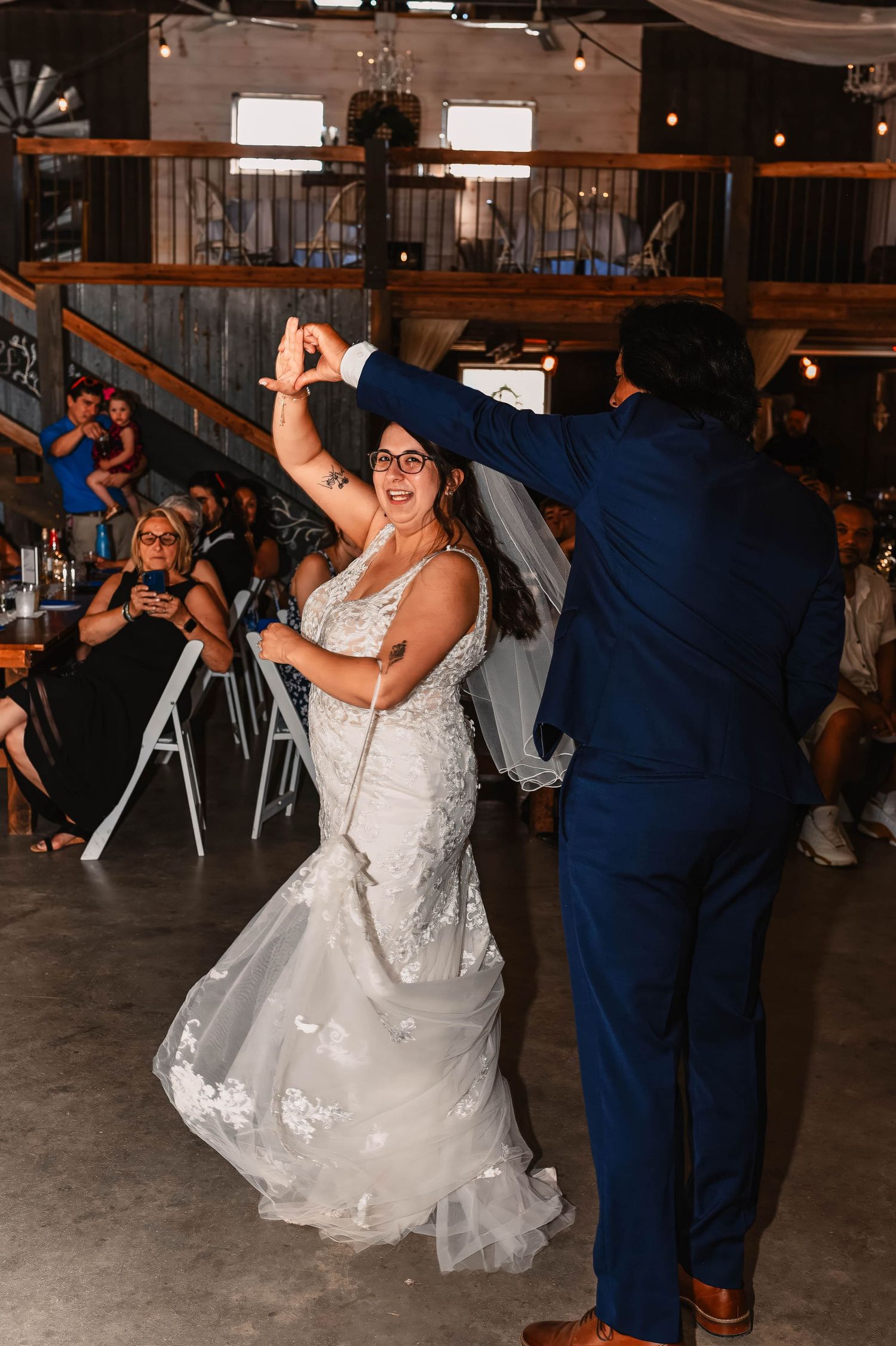 Couple dancing at wedding reception with bride's dress twirling in motion.