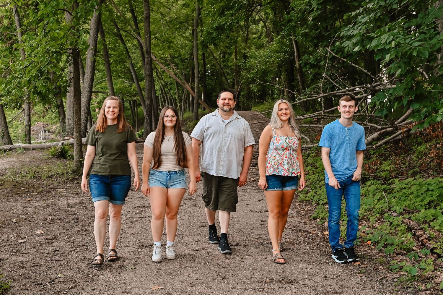 Group walking together on a wooded trail during summer.