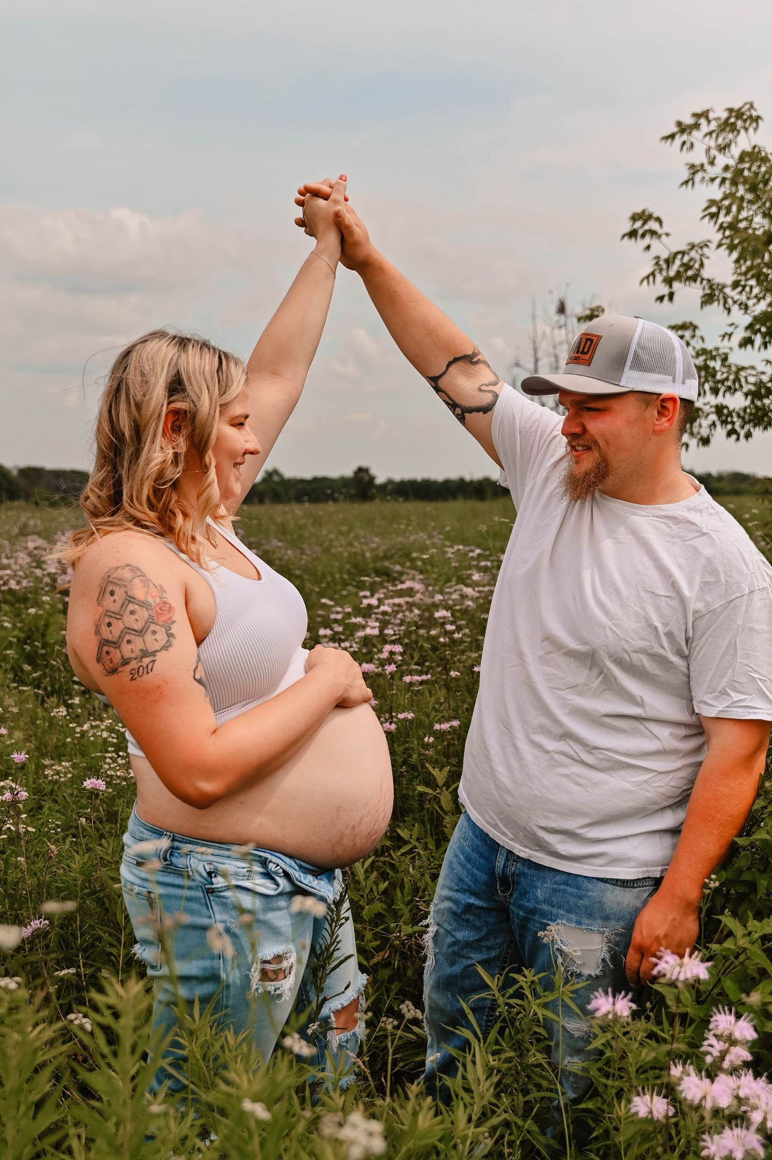 Dancing couple shares intimate moment in a blooming meadow during summer.