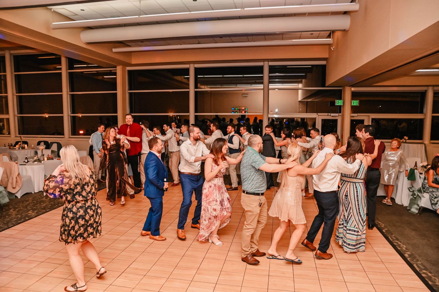 Wedding reception dance floor with guests dancing in panoramic view.