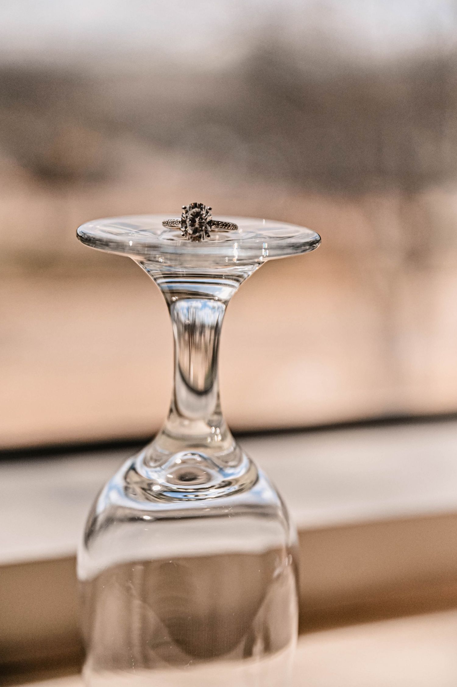 Close-up detail of upturned wine glasses on a neutral background.