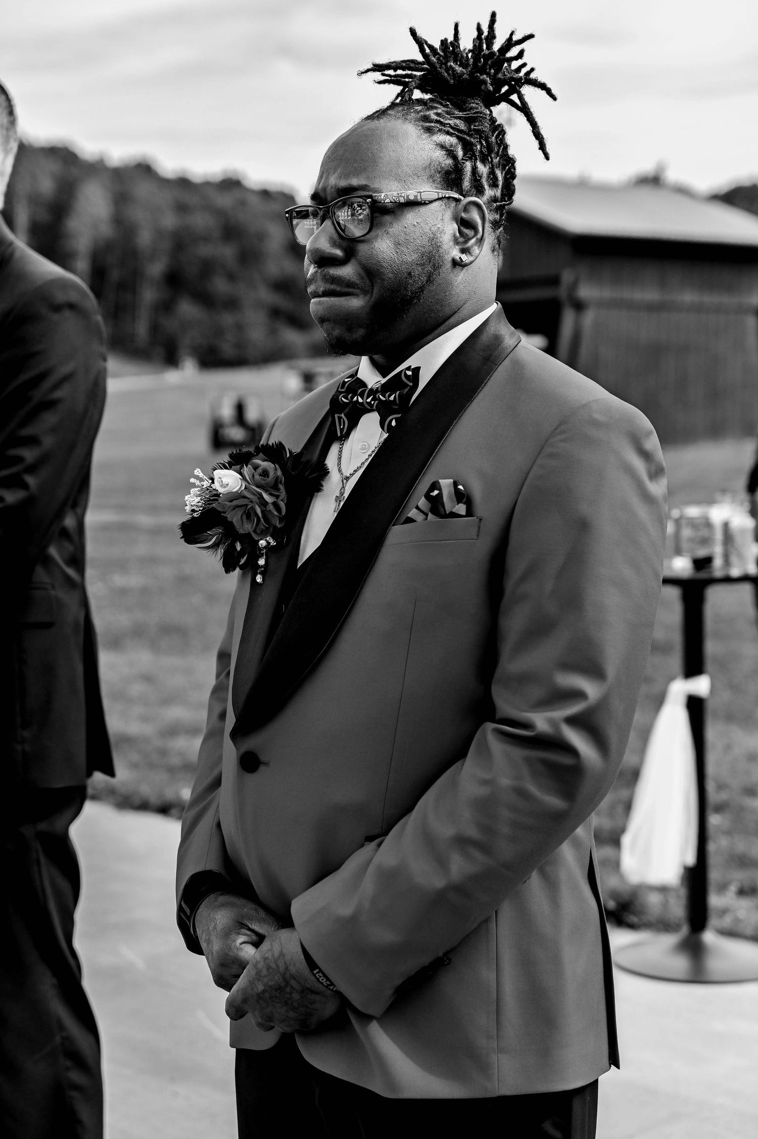 Black and white portrait of groomsmen in formal attire at outdoor wedding.