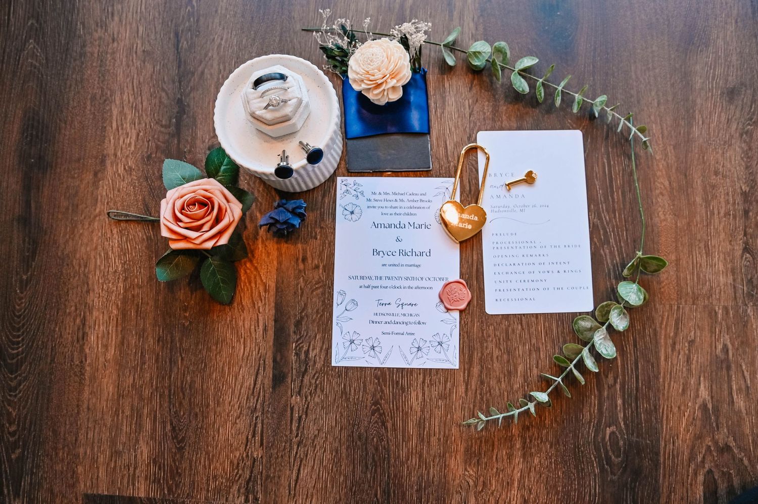 Wedding invitation details and decorative elements arranged on a dark wooden surface.