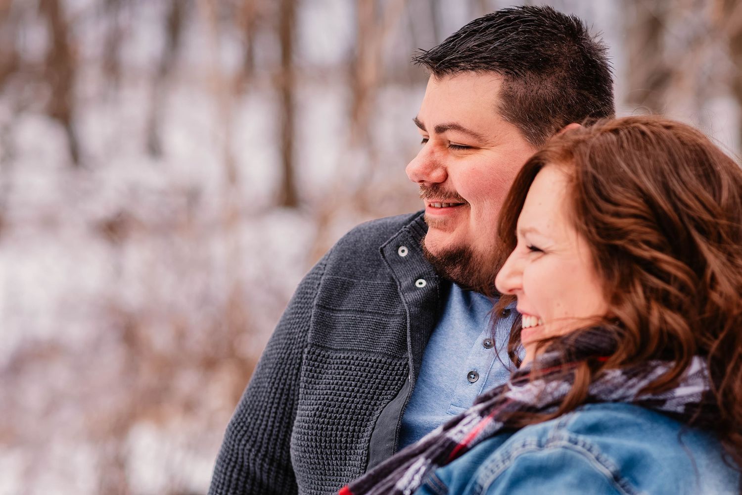 Couple sharing intimate moment outdoors in winter setting.