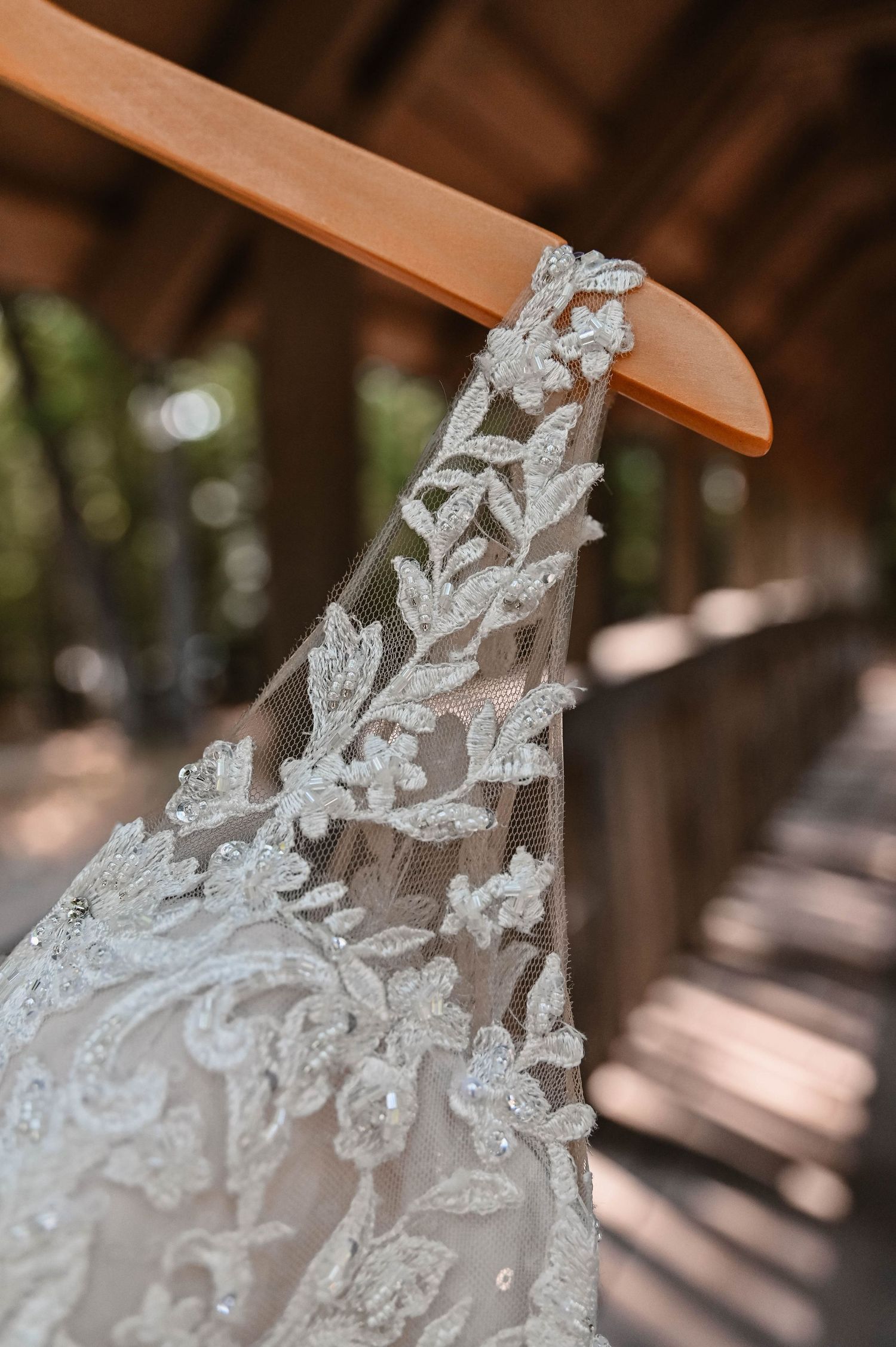 Close-up of delicate white lace pattern on wedding dress fabric.