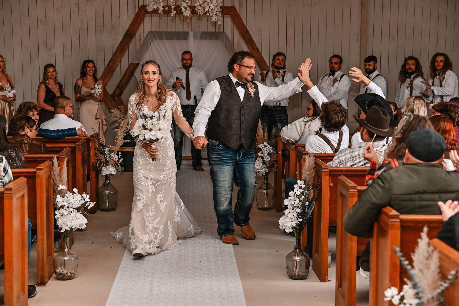 Joyful celebration in a church aisle during a wedding ceremony with guests looking on.