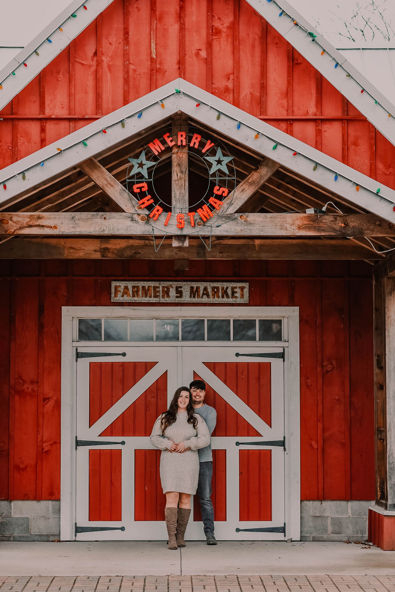 Red barn-style farmers market building with white trim and decorative stars.