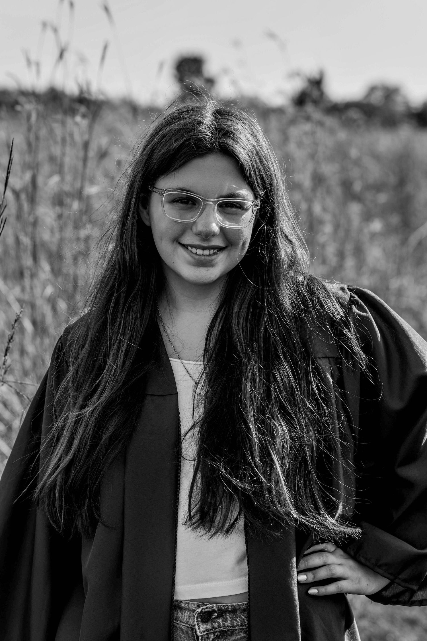 Black and white portraits in blazer showing natural expressions against field backdrop.