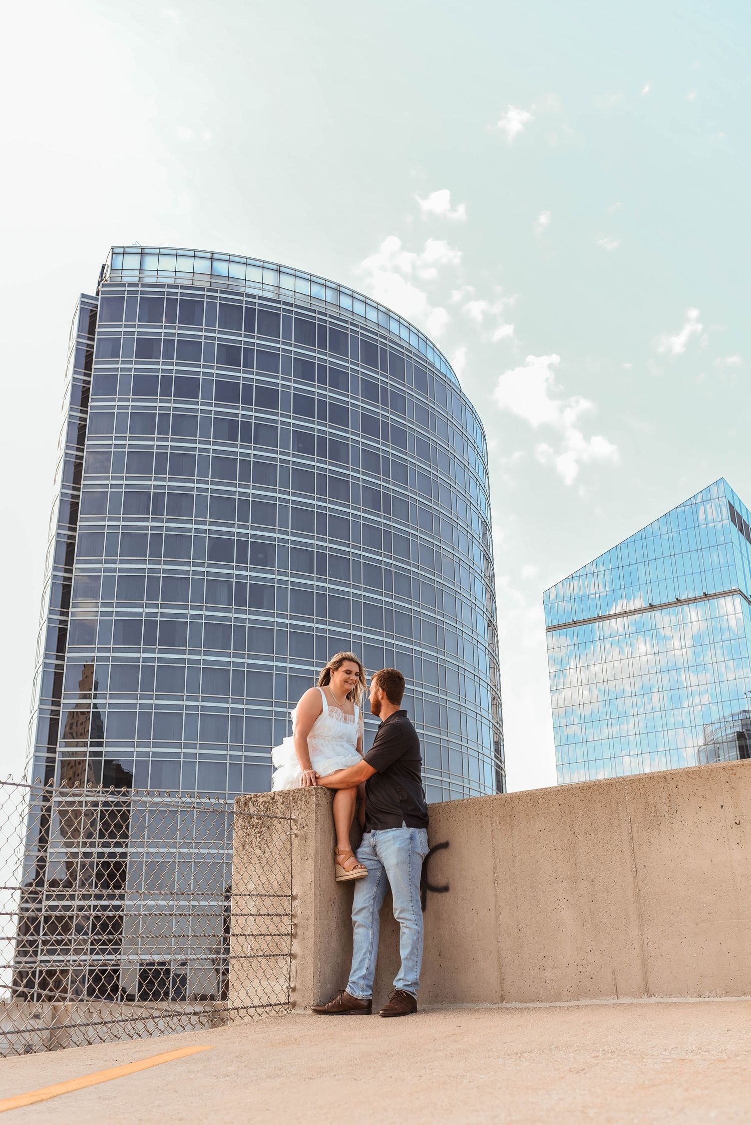 Series of romantic moments against modern glass office buildings on a rooftop.