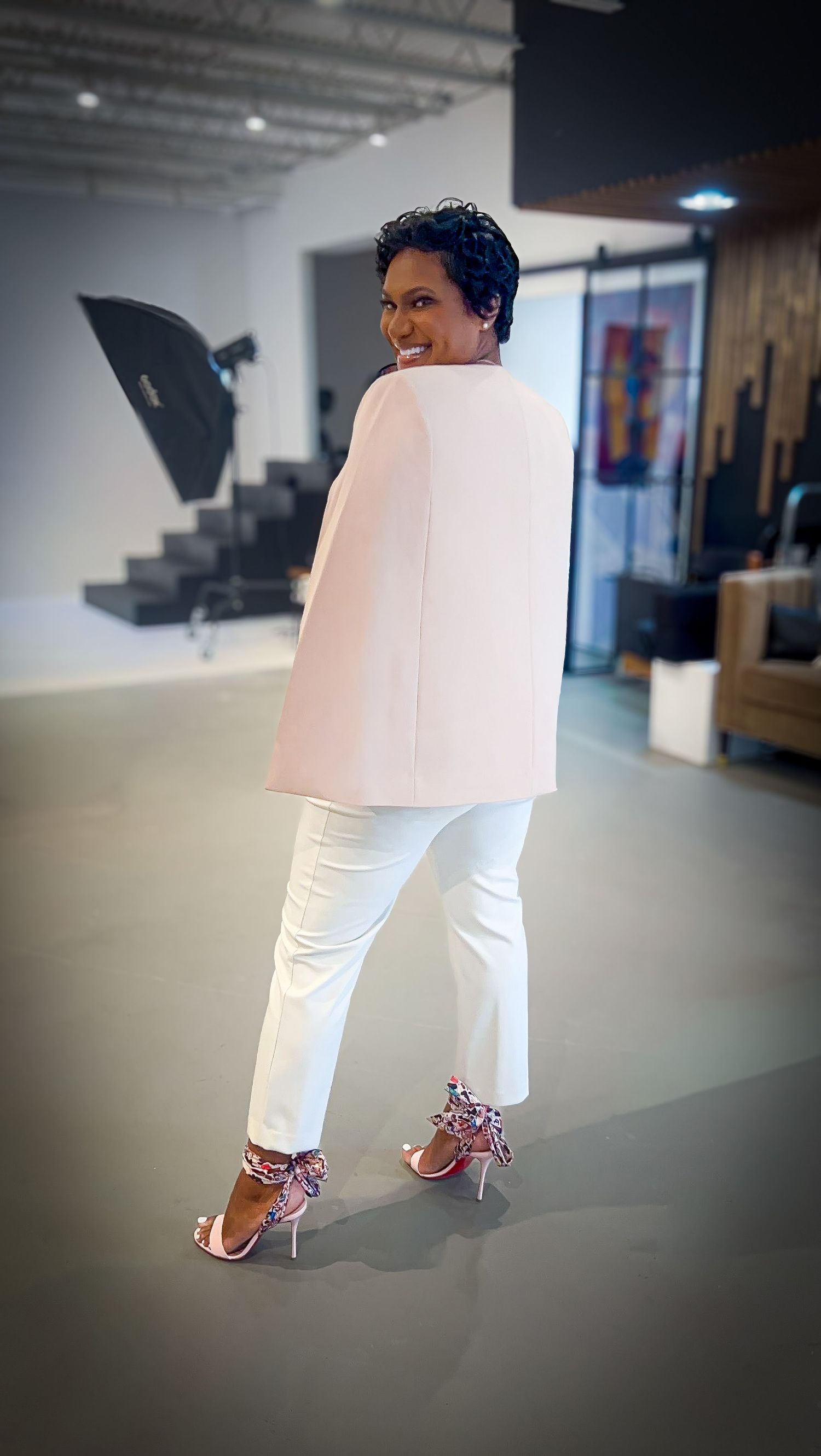 White pants and sparkly high heels shown in a series of close-up shots on a studio floor.
