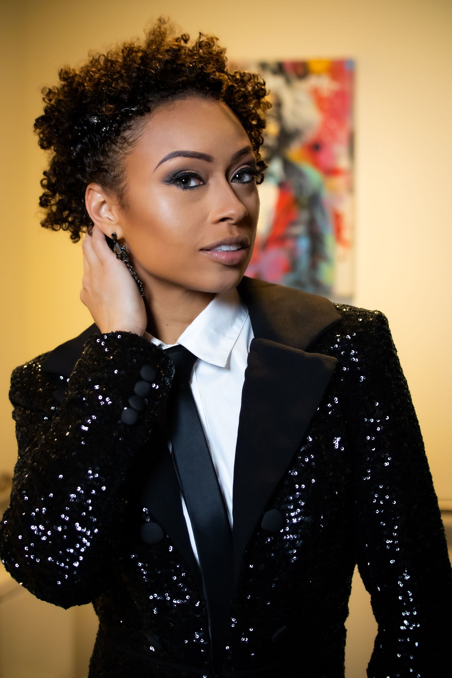 Glamour shots featuring sparkly black blazer and white shirt against warm background.
