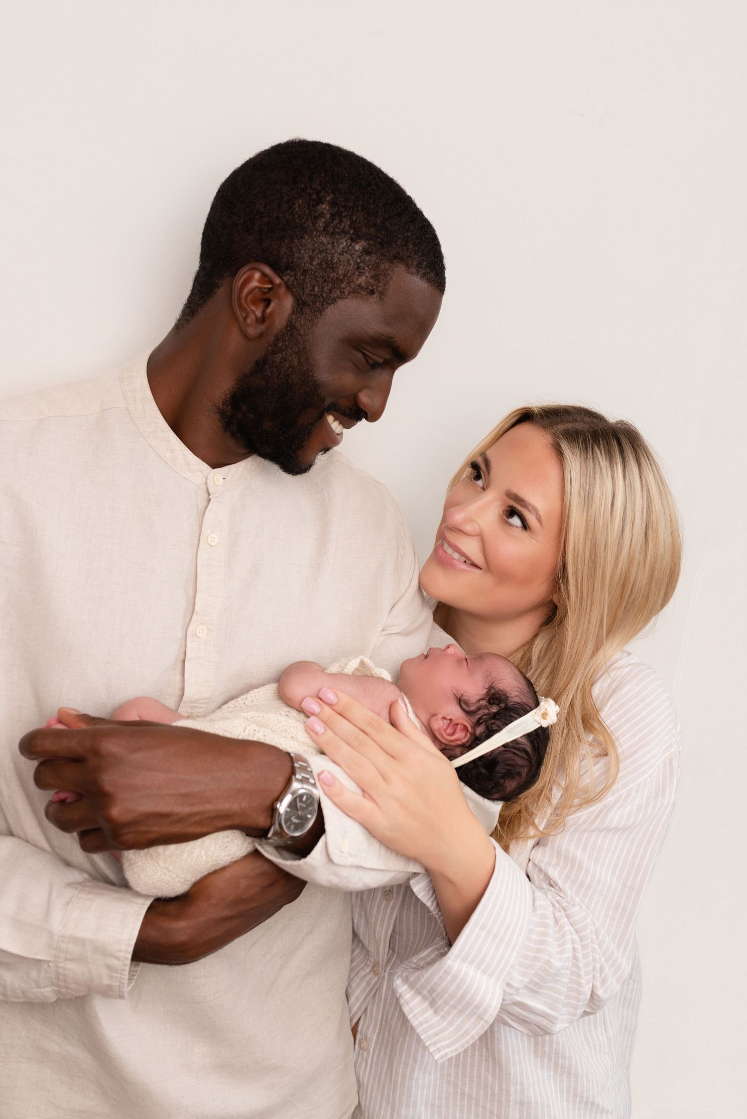 New parents sharing tender moment while holding their newborn baby.