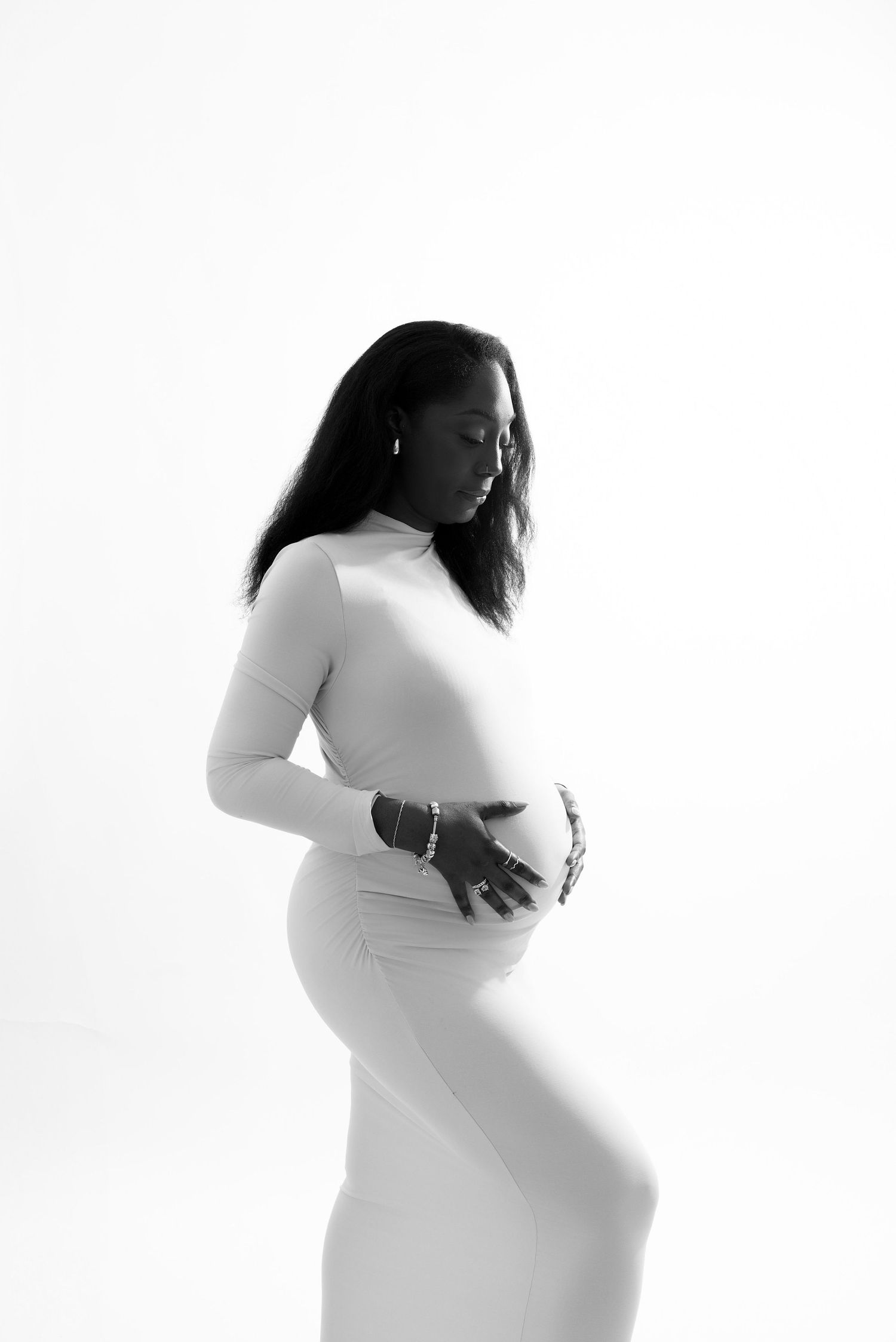 Artistic black and white maternity photo showing silhouette against white background.