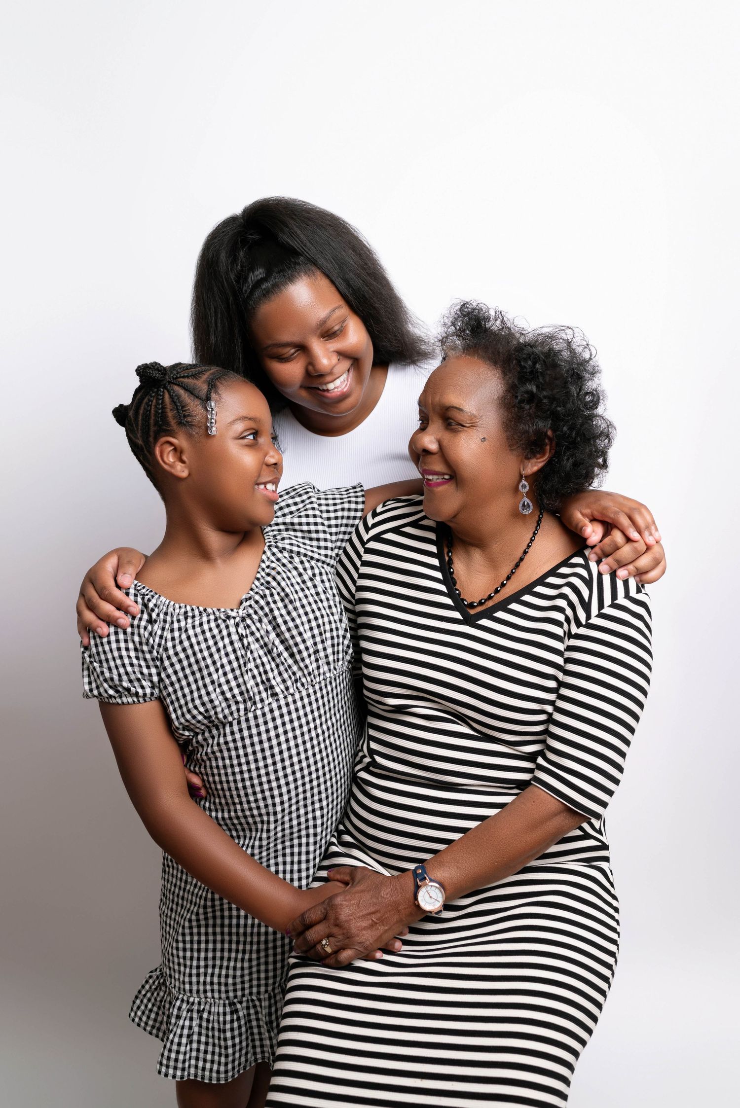 A heartwarming series of candid studio portraits showing joyful embraces between two people wearing stripes and gingham.