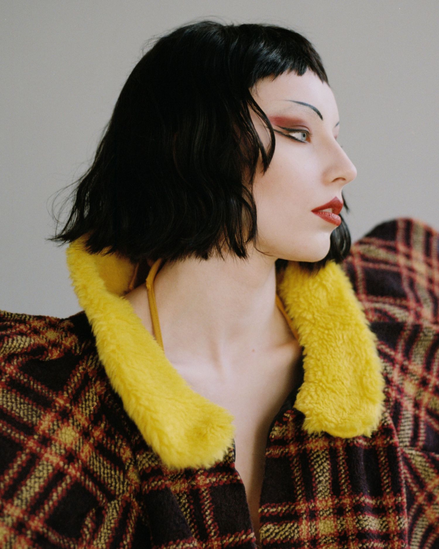Film portrait of a model with a blunt short haircut and punk makeup. Wig and makeup by Steph George.