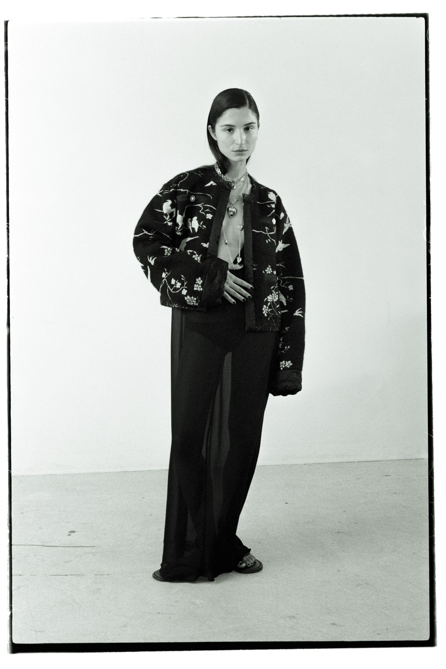 Black and white film portrait of Montréal influencer Andrea Ricci wearing a jacket embroidered with birds from Chanel Métiers d'arts '24/25.