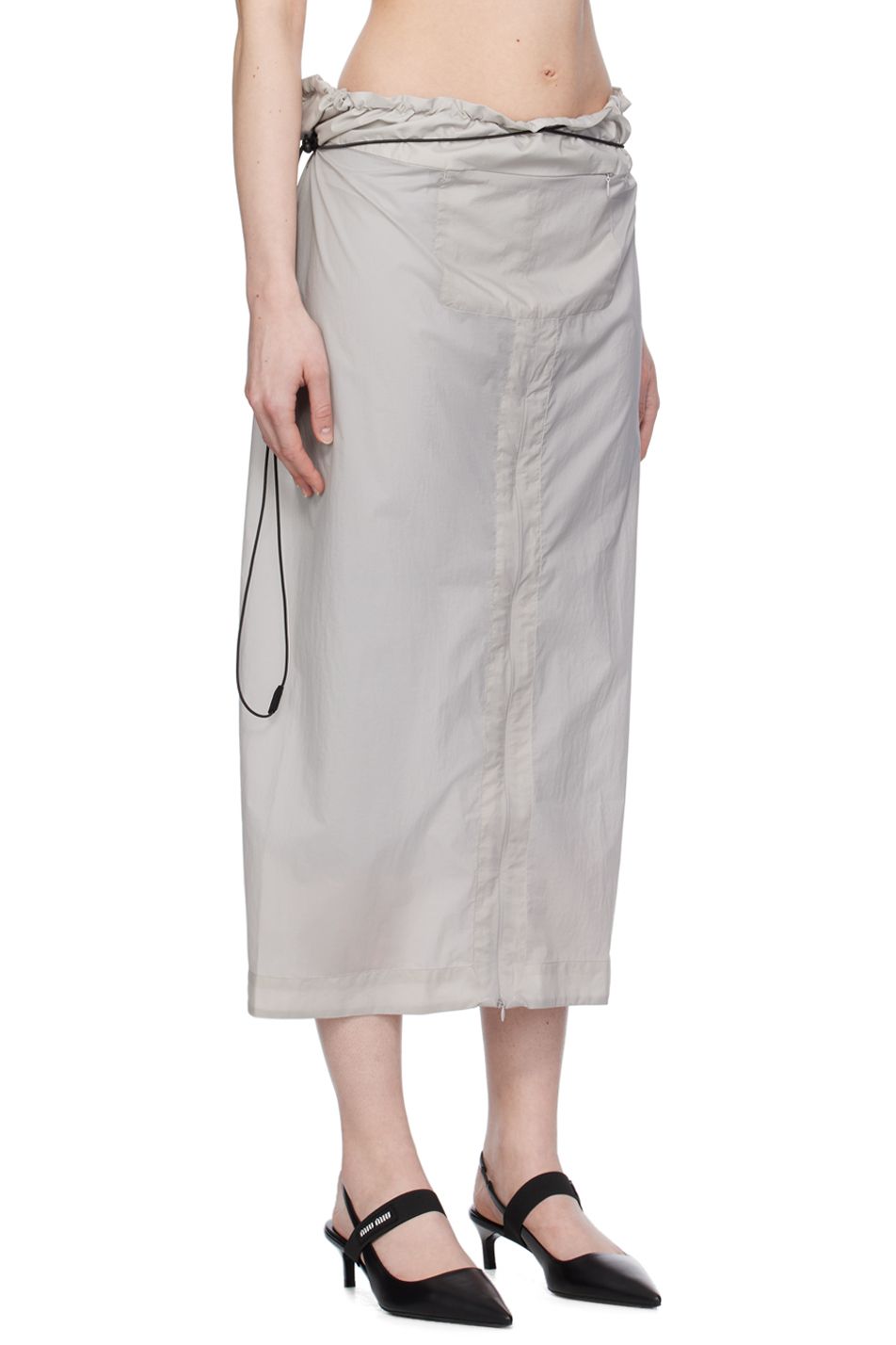 The side view of a grey nylon skirt by Johanna Parv on model.
