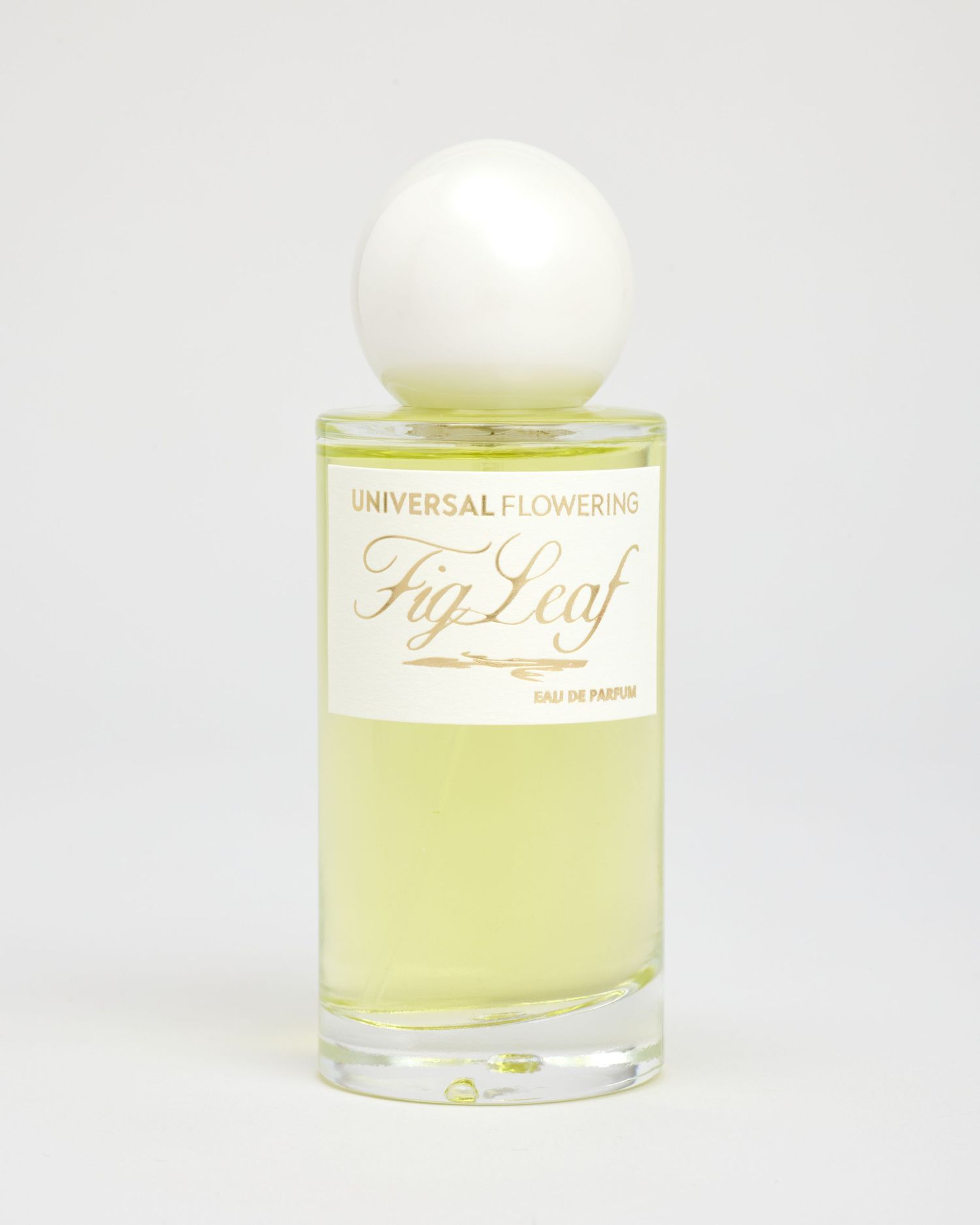 A bottle of Universal Flowering's Fig Leaf perfume sits on a light grey backdrop.