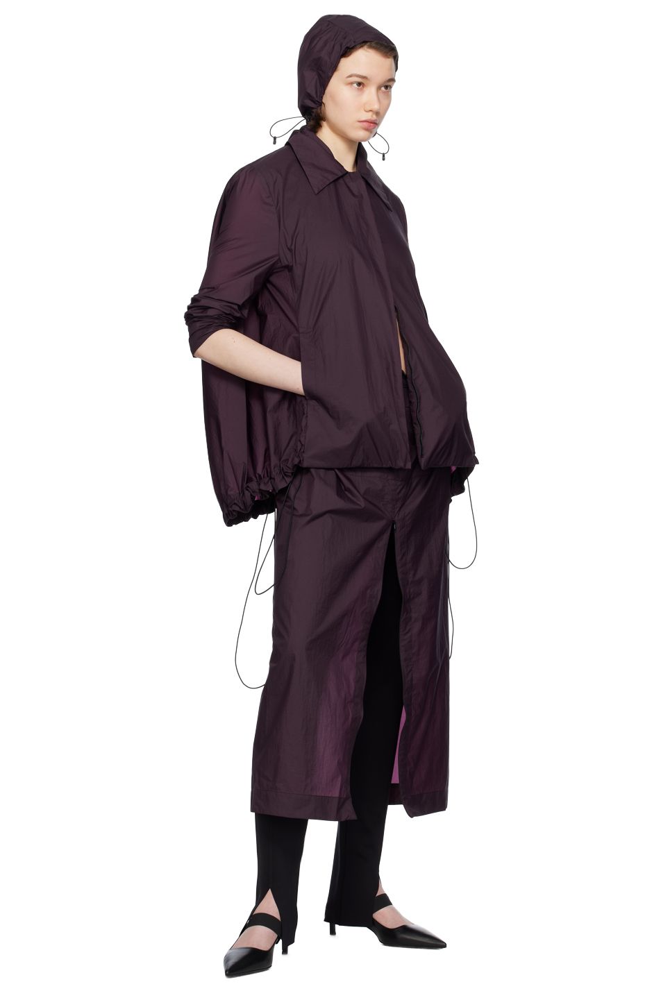 A model wears an aubergine hat, jacket, and skirt by designer Johanna Parv for SSENSE.