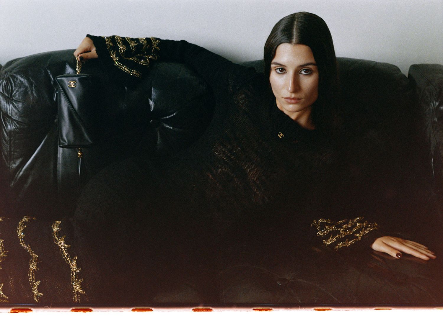 Andrea Ricci wearing a black and gold dress and handbag from the Chanel Métiers d'arts '24/25 collection. Shot at Maison Singulier